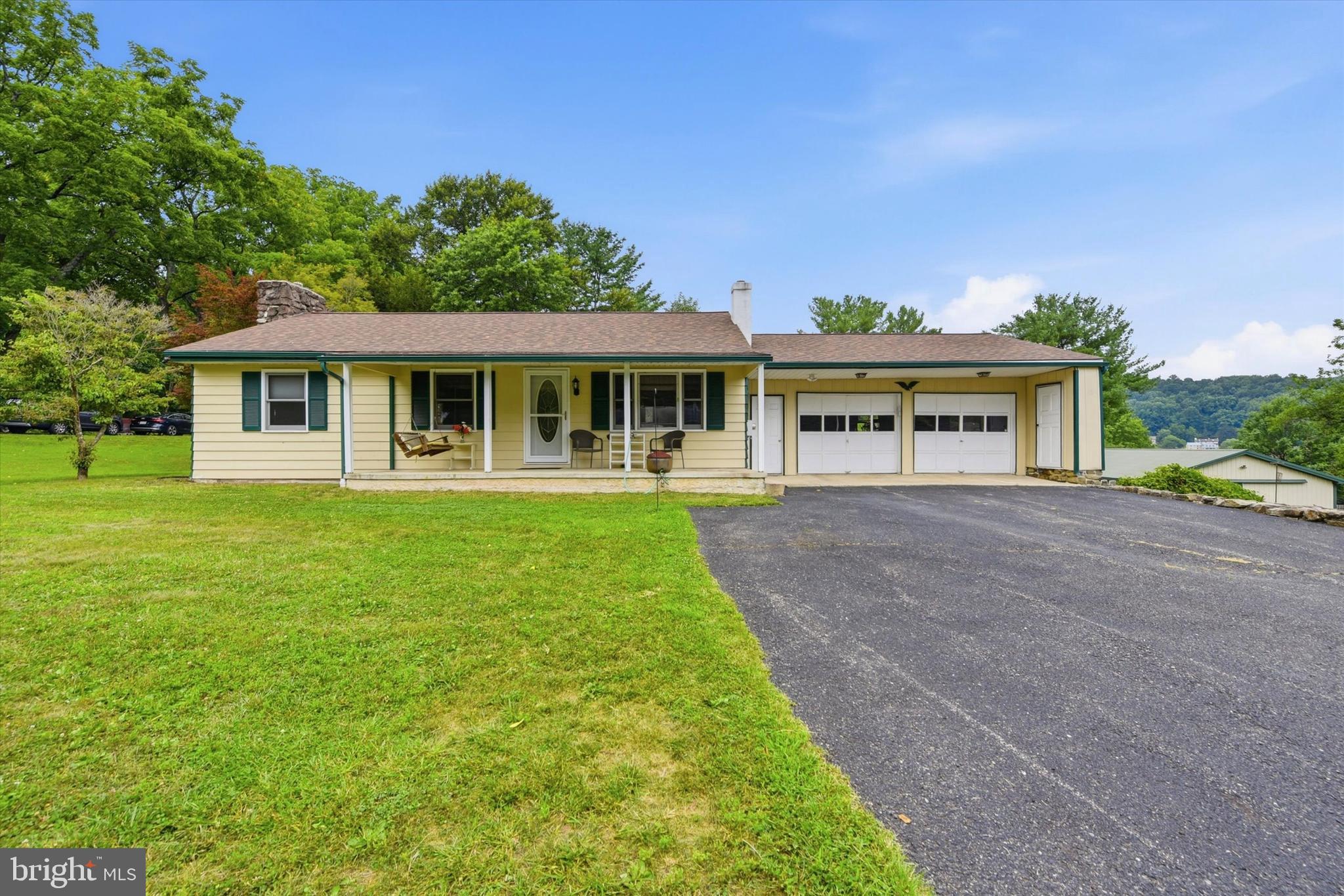 This beautifully updated and maintained ranch home sits on a flat, one-acre lot in a peaceful setting. Located in Knauertown with an Elverson zip code, it falls within the top-tier Owen J Roberts School District and is a short distance from Saint Peters Village, the historic Borough of Elverson, French Creek Park, State Game Lands, and the Horseshoe Trailhead, which is just across the road.  A relaxing front porch welcomes you into the main level of this Ranch-style home, where a sunny living room awaits with abundant windows, a newer 75” wall-mounted TV, and plenty of room for furnishings. The dining room offers inside access to the oversized two-car garage and new sliders with convenient between-the-glass blinds leading out to a large deck. The kitchen features flame cooking courtesy of an owned propane tank, ceramic tile flooring, cherry cabinets, and a small island perfect for coffee breaks and food prep.Down the hall from the living room, you'll find a linen closet, a coat closet, and a renovated full hall bath with step-in shower. Three bedrooms complete this level: the first is ideal for a home office or nursery, while the second and third have  generously sized closets. Pull-down stairs to the attic offer potential storage space. Throughout the home, nine-foot ceilings and plaster walls reflect solid, quality construction.  The partially finished basement serves as a recreation room or a fourth bedroom, complete with large closet.   Highlights include a stone propane fireplace, a wet bar, a Broan exhaust fan that doubles as a wireless speaker, and a large closet. Note that the Dutch door from the DR to the basement serves as a way for warmth from the fireplace to rise from the basement and air conditioning to cool the basement level.   The basement’s full bath includes a jetted tub/shower. The unfinished area houses a large pantry/storage closet and a utility room with an oil tank, furnace and the electrical, which is hooked up to a whole-house generator, standing by for potential power outages. The laundry room offers multiple storage spaces, including one that conceals the well equipment (upgraded in 2020). Ask about the discreet, hidden storage closet, perfect for firearms and valuables.  Outside, the large wooden deck includes a shaded area and an oak TV stand, with a stone patio below. The outbuilding houses three adjoining spaces: another two-car garage with its own gravel driveway, a large workshop equipped with cabinetry, and a smokehouse with electricity and a stainless cutting table for the hunter. Note that the smoker needs to be reconnected — which should be an easy fix.  This one-of-a-kind property offers the perfect blend of privacy, updates, and outdoor living.  Perfect for those wanting the easy lifestyle of a Rancher with plenty of living space, both inside and out.