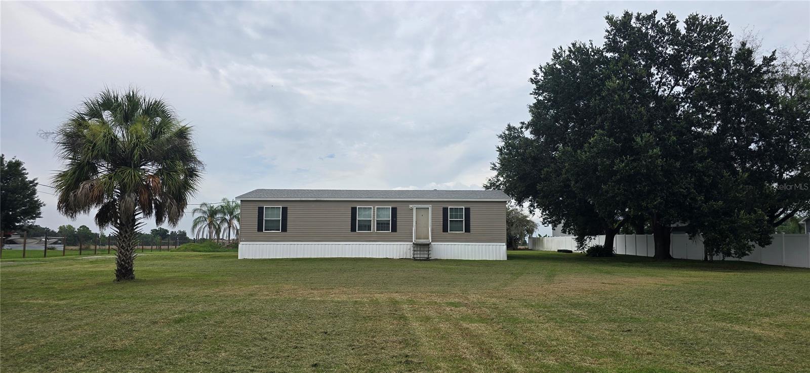 Under contract-accepting backup offers. Country living, generous space, and meaningful recent improvements come together on 1.07 acres in Plant City. With NO HOA, NO DEED RESTRICTIONS, AS-1 zoning, and a Flood Zone X designation, this Jacobsen double-wide manufactured home offers the freedom and flexibility that can be so difficult to find at this price point.Inside, the three-bedroom, two-bathroom layout is open, comfortable, and filled with natural light. The kitchen, dining area, and living room flow together beneath decorative tray ceilings, creating an inviting central space for everyday living and entertaining. The kitchen features abundant cabinetry, a large center island with seating, and a hidden walk-in pantry that delivers the kind of storage every kitchen needs. The range, microwave, and dishwasher are included.The primary suite offers a ceiling fan, walk-in closet, and private en suite bathroom complete with a garden tub, separate glass-enclosed shower, oversized single-sink vanity, built-in cabinetry, and linen storage. Both guest bedrooms also include walk-in closets, while the guest bathroom provides a tub and shower combination, single-sink vanity, and additional built-in linen and storage cabinetry.Outside, the expansive 40-by-25-foot attached carport with a concrete foundation offers approximately 1,000 square feet of covered space with plenty of room for parking, outdoor gatherings, hobbies, equipment, or additional storage. The spacious homesite provides an open yard and plenty of room to put the property to work for your lifestyle.Major improvements include a new shingle roof and new skirting completed in 2025, along with a new 3.5-ton HVAC system installed in 2026. The property is served by a private well and septic system and includes a water softener and filtration system, plus an electric water heater.If you have been searching for affordable acreage, recent big-ticket updates, abundant storage, and the freedom of country living without community restrictions, 215 Karppe Road deserves your attention. Schedule your private showing and come see the possibilities for yourself.