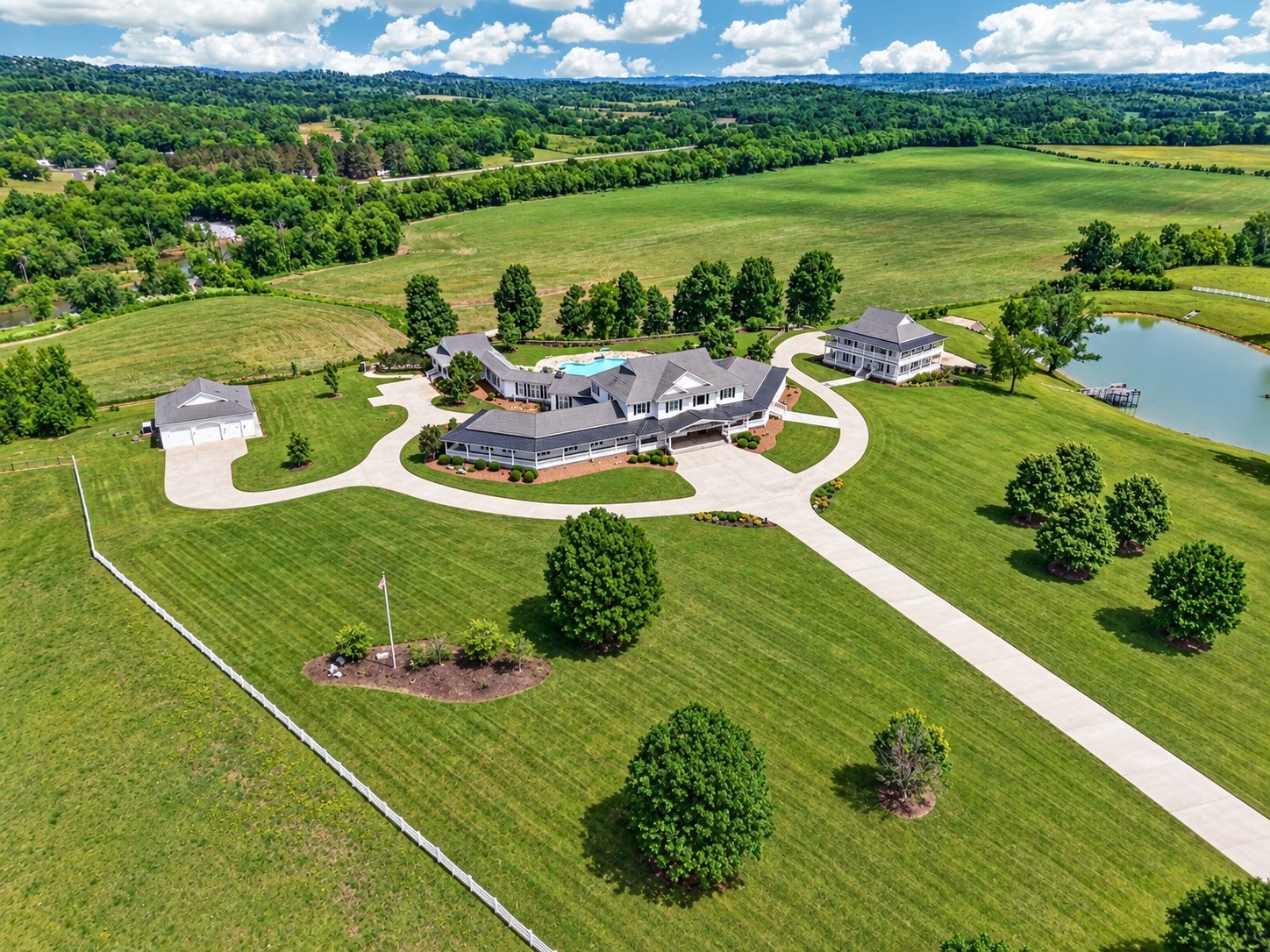 A truly exceptional estate offering privacy, luxury, versatility, and extraordinary space. Set on more than 34 acres, this remarkable property combines an impressive primary residence with multiple additional buildings, resort-style outdoor amenities, and endless possibilities for entertaining, extended family, recreation, storage, or business use.The stunning main residence offers 6 bedrooms and 8.5 bathrooms, with an emphasis on quality craftsmanship and generous living spaces. Features include soaring ceilings, beautiful wide trim, hardwood and tile flooring, and granite counter tops throughout. The home is designed for both elegant everyday living and grand-scale entertaining, with four kitchens and private living quarters featuring a separate entrance, providing exceptional flexibility for guests, extended family, or multi-generational living.The outdoor setting creates a private retreat of its own. Enjoy the sparkling swimming pool surrounded by extensive custom rock work and a massive entertainment room with direct access to the pool, creating the perfect environment for gatherings, celebrations, and unforgettable evenings with family and friends.The property continues to impress with two substantial additional buildings.The second building is an impressive three-story structure with two levels that are heated and cooled. The basement level features a garage, offering tremendous additional space and versatility.The third building is a large heated shop equipped with an over sized door, making it ideal for equipment, vehicles, hobbies, workshop space, or a variety of personal and professional uses.The expansive grounds are enhanced by vinyl fencing, a large pond, and a private pier, providing a peaceful setting for recreation and enjoying the outdoors.This is far more than a home—it is a private estate designed for exceptional living.