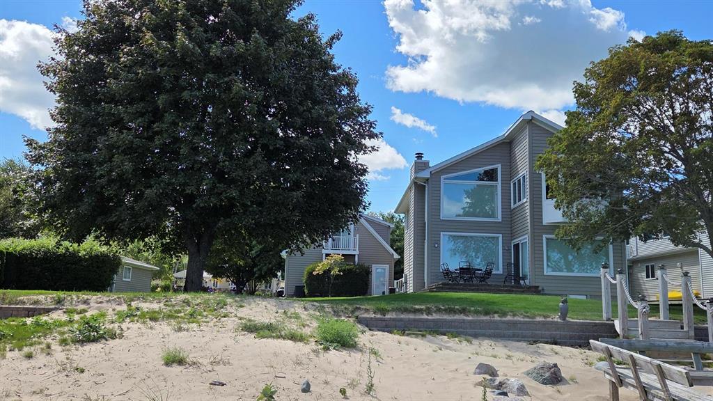 Walk the sandy shore of Lake Huron just steps from this stunning 4 bedroom home offering top notch craftsmanship! "120 FEET OF FRONTAGE!" The main floor living room, kitchen & newly added formal dining area is complete open concept w/vaulted ceilings, fireplace, and stunning panoramic views that surround you, complete with a first floor bedroom & full bath.  Many updates include; newer addition/beautifully crafted second floor master bedroom on the lakeside, custom bath featuring a walk-in euro shower w/cherry cabinetry/quartz counters, newer custom kitchen with quartz counters/custom under-lighted cabinets, roof, furnace/AC, Generac whole home generator, electric Hunter Douglas blinds & encapsulated crawl.  Perfect for your guests is the 462 sqft. living area above the garage, with a full bath & views of the lake. The 32x20 second garage is heated w/electricity & epoxy flooring.  This home has been a successful Airbnb for the past two summers!  TURN-KEY FURNISHED! Municipal & private marina are 3 miles south...bring your boat!