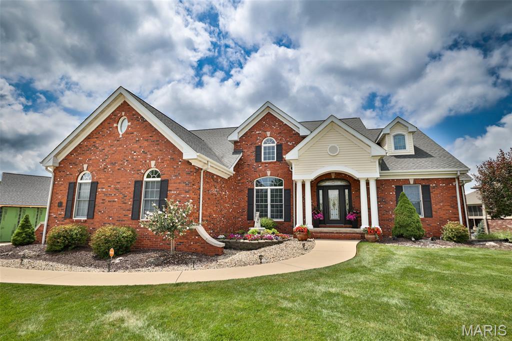 Architecturally significant and masterfully crafted, this extraordinary custom residence is a timeless showcase of luxury, design, and craftsmanship. Designed by a renowned local architect, every space has been thoughtfully curated with dramatic architectural details, soaring volume ceilings, custom ceiling treatments, and an impressive indoor waterfall feature that creates an unforgettable first impression.The spectacular great room is bathed in natural light through walls of windows, seamlessly connecting to the outdoor living spaces and capturing breathtaking views of the neighboring water features. Designed for both everyday living and exceptional entertaining, the chef's kitchen is a true centerpiece, featuring a distinctive circular and turret ceiling design, granite countertops, premium stainless steel appliances, double ovens, wine cooler, abundant custom cabinetry, and a cozy fireplace.The luxurious main-level primary suite is a private retreat showcasing rich African mahogany flooring, a dramatic barrel-vault ceiling, custom walk-in closets, and a beautifully renovated spa-inspired bath complete with granite vanities, a glass walk-in shower, and its own fireplace.The upper level offers a private guest ensuite overlooking the great room from its own balcony, while the finished walkout lower level expands the home's incredible living space with a spacious family and game room, deluxe wet bar/kitchenette, recreational area, extensive storage spaces, office area, fireplace, two additional bedrooms- one as an additional en-suite, and an additional bath. Step outside to experience resort-style living on the expansive double-tier deck overlooking professionally landscaped grounds and pond- currently under service for re-beutification by association.  Additional amenities include an irrigation system, whole-home sound system, and a side-entry three-car garage.Perfectly positioned just 20 minutes from Downtown St. Louis, this remarkable home offers an exceptional combination of architectural beauty, luxurious finishes, and an unmatched setting. Homes of this caliber rarely become available—this is a truly one-of-a-kind opportunity.