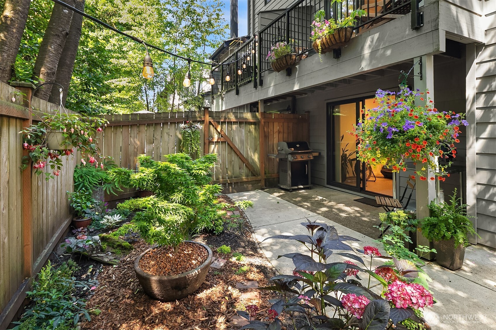 If you are seeking a soul-less, grayed-out townhome, this property is definitely not for you. Thoughtfully rebuilt from the studs out in 2021, this residence prioritizes warmth, character, and uncompromised craftsmanship. Beyond the essential updates—like all-new plumbing, electrical, windows, and high-efficiency ceramic heating—this home features rare luxuries omitted by typical renovations. Enjoy absolute quiet with soundproofing drywall and solid-core doors, alongside eco-friendly cork flooring and a whole-house water filter. The chef's kitchen showcases elegant, book-matched hemlock cabinets and Bosch, Liebherr and Miele appliances, while smart lighting controls and top-down/bottom-up blinds offer effortless ambiance. Outside, a lush garden patio offers a private sanctuary, while the newer deck (2019) and brand-new roof (May 2026) provide peace of mind. Positioned at the back of the community, your living spaces look out over a serene, verdant greenbelt. Step inside and the quality and warmth of the design will draw you in and invite you to imagine making this your home.  With a 91 Walk Score, you can leave your car in the insulated garage and take the ten-minute stroll to Burien’s eclectic shops, celebrated dining scene, farmers market and numerous year-round community events. Minutes from PCC, Trader Joe's, Seahurst Park, the RapidRide F Line and the airport. Some homes truly must be experienced in person—don't miss your opportunity to acquire this luxurious property.