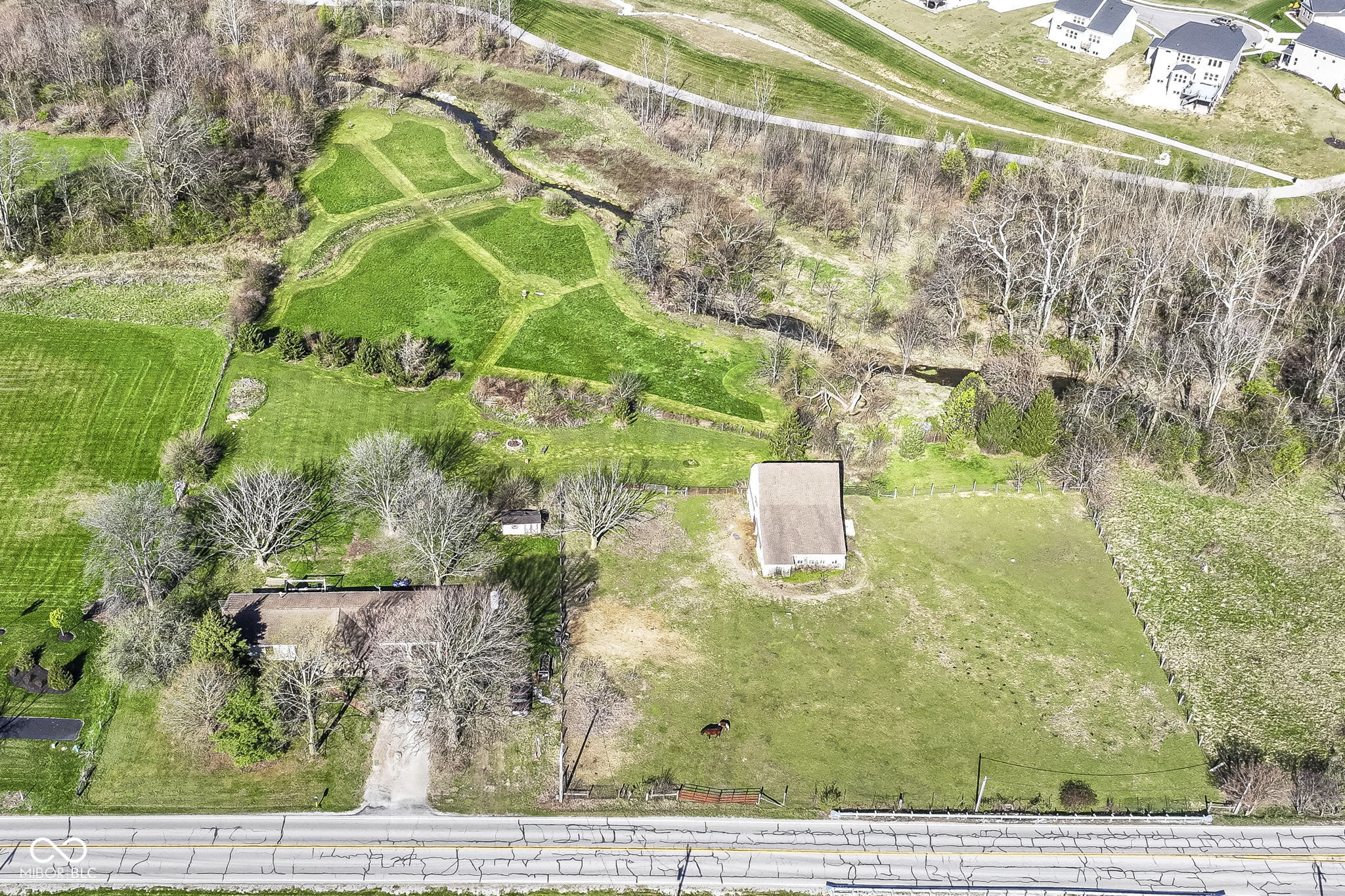 Rare 2.49-Acre Opportunity in Prime Fishers Location. Situated just off Cyntheanne Rd, this 2.49-acre property (2 parcels) offers a unique opportunity in the heart of Fishers. The 1-acre homesite includes a 1,456 sq/ft ranch home with a 2-car attached garage, while the additional 1.49-acre fenced parcel features a horse barn-perfect for those seeking space, privacy, or future development potential.  The home is being sold AS-IS and requires a full renovation, making it ideal for investors, rehabbers, or anyone looking to build their dream home. Originally designed as a 3BR/2BA, the sellers opened up two bedrooms to create an oversized primary suite, but it can easily be converted back to three bedrooms.  The property is currently serviced by well water, septic system, and propane gas.  Located just minutes from Hamilton Town Center, top-rated HSE Schools, Geist Reservoir and all the amenities of Fishers area.
