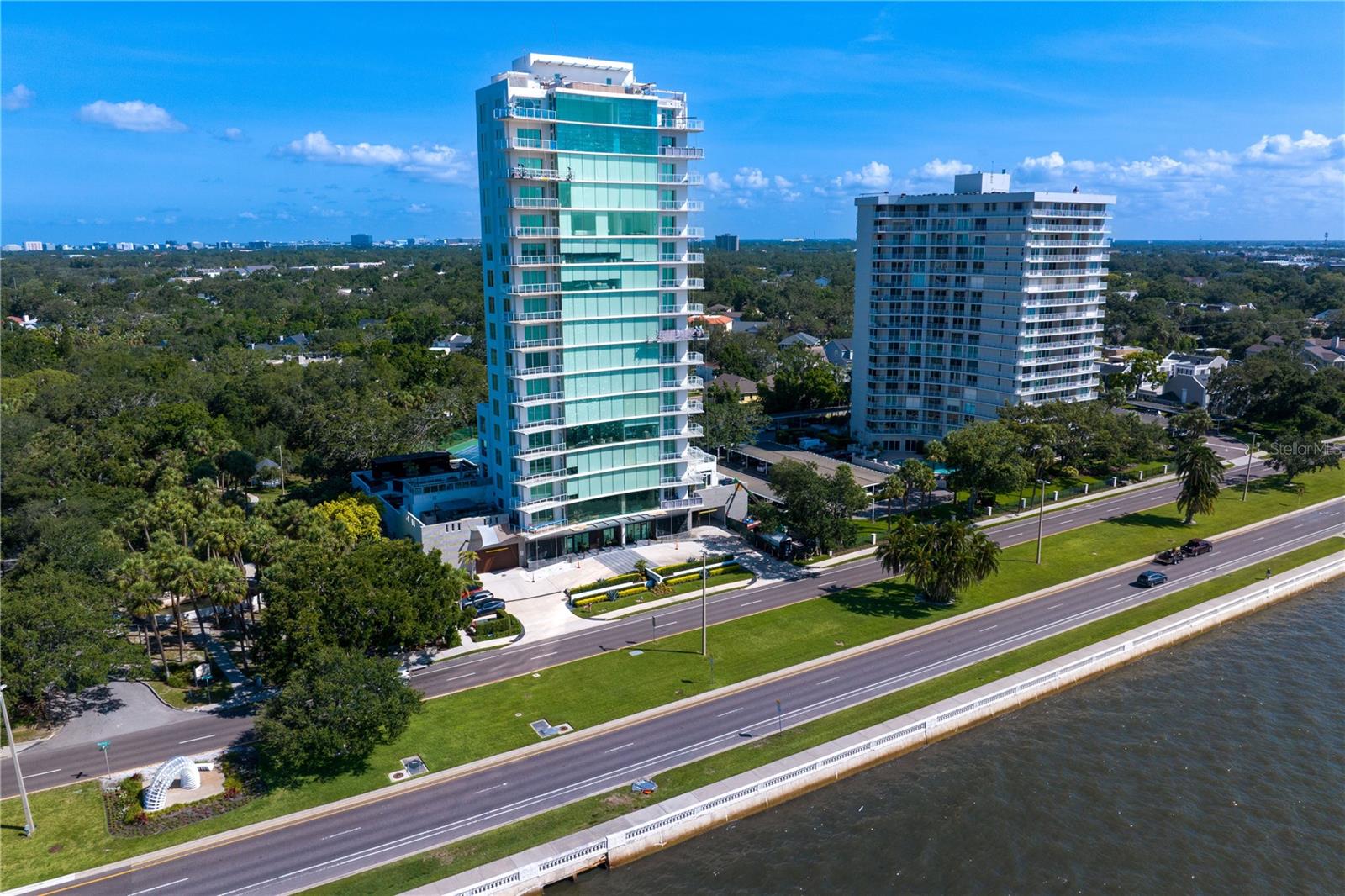Residence 200 at The Sanctuary redefines elevated condominium living with over 10,000 square feet of combined interior and exterior living space overlooking iconic Bayshore Boulevard. A rarely found private outdoor terrace and garden retreat delivers the scale, privacy, and indoor-outdoor lifestyle more commonly associated with a single-family residence. Located within a boutique tower of only 15 homes, the over 5,000 square feet of private pergola-covered living areas, outdoor kitchen with gas grill currently in progress, wood-clad terraces, and a tranquil koi pond define an outdoor environment seldom associated with high-rise living. As the second largest residence in the building, this 5,090-square-foot full-floor plan begins with secure private elevator entry opening to sunlit interiors where walls of glass frame Bayshore Boulevard, the city skyline, and unobstructed Tampa Bay views. Refined architectural detailing, curated finishes, and a design-forward aesthetic create interiors that feel sophisticated yet highly livable. Expansive living and dining areas flow into a chef’s kitchen appointed with Gaggenau appliances, custom cabinetry, and a butler’s pantry. The floor plan includes a theater or media room, three-bedroom suites each with its own ensuite bath, and two additional half baths. The bonus room offers flexible use and may offer fourth-bedroom potential with buyer modifications, subject to buyer’s independent verification of all requirements. Interior features include Italian terrazzo tile flooring, smart home integration, a spa-inspired primary bath with steam shower, and extensive integrated storage throughout. Landscaped garden spaces include fruit trees, a chef’s herb garden, and multiple areas designed for dining, entertaining, and quiet retreat. Even more uniquely, this private outdoor space provides direct access to the building’s amenity level, including the pool, allowing for seamless indoor-outdoor living rarely available in luxury condominium residences. Two assigned private garage parking spaces are included, with the potential for four spaces through the addition of car lifts by buyer. The building is further enhanced by a generator for added peace of mind. The Sanctuary offers amenities including a pool, spa, and fitness center within a highly private residential setting along Bayshore Boulevard. Residence 200 offers the privacy, outdoor scale, and presence of a single-family residence with the lock-and-leave convenience of luxury condominium ownership. Note: Unit 200 should not be evaluated on interior price per square foot alone, as its private terraces carry substantial contributory value not reflected in air-conditioned square footage and not represented in prior in-building sales. Photos were taken at various times over the past year.