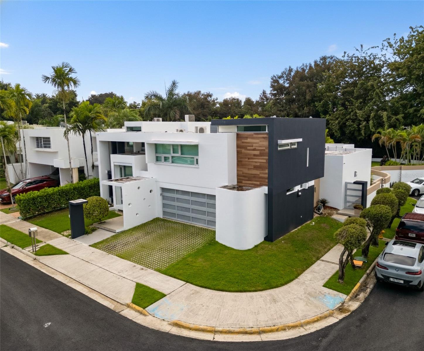 Luxury corner residence in El Mirador, San Juan. Fully remodeled and expanded with modern design and excellent spaces for entertaining. 3,714 sq ft of construction on a 1,100 sq meter lot. Features a swimming pool with jacuzzi and private backyard, outdoor entertainment area with kitchen and BBQ, plus a second-floor terrace overlooking the patio. Private home theater with seating and sound system. Remodeled kitchen (2022) with Bosch dishwasher, wine cooler, and porcelain countertops. Climate-controlled wine cellar and marble floors throughout. Offers 4 bedrooms and 5 bathrooms, including a Junior Suite with en-suite bath and walk-in closet, and an expanded primary suite with luxury bathroom and two walk-in closets. Equipped with 20kW generator, 600-gallon water cistern, gym area with office, and electric hurricane shutters.