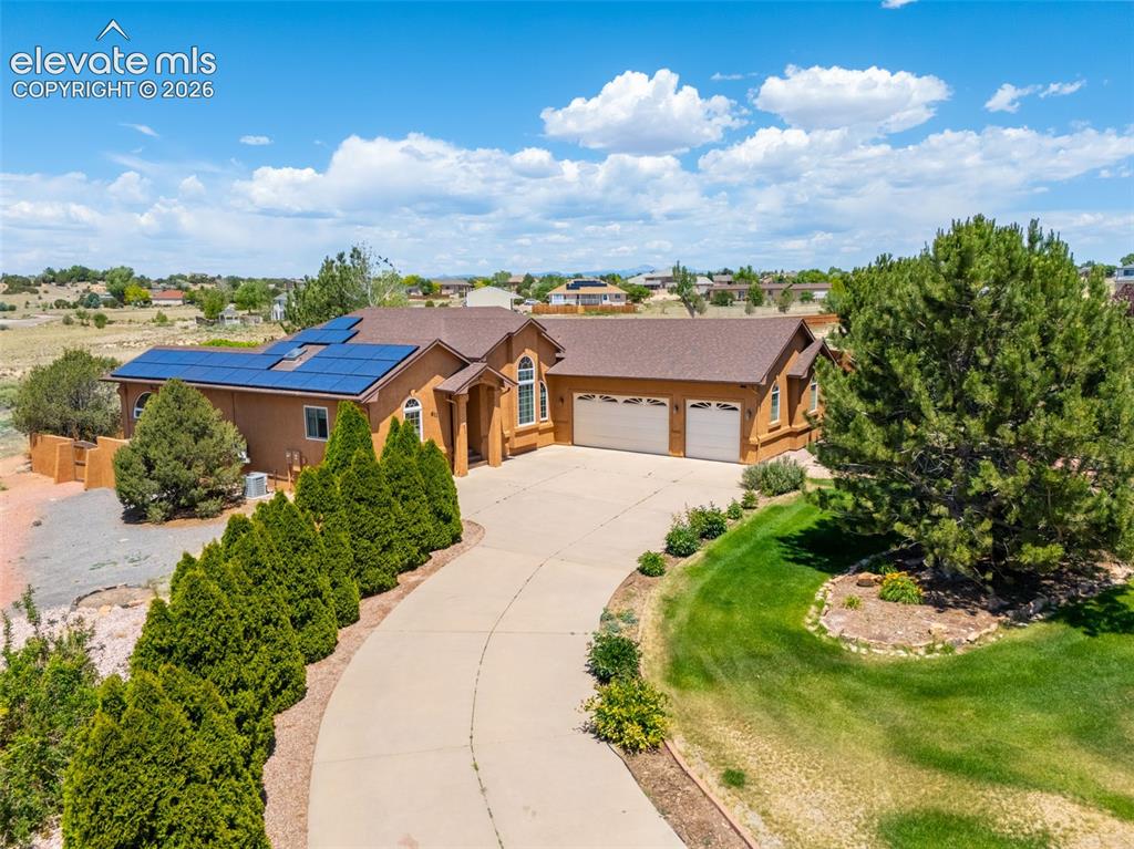 Experience the charm of Tuscany in this beautiful home set on a private, secluded acre. The backyard retreat features an enclosed deck with earth-toned stucco, arched windows, a sunroom, and an automatic awning. Stone pathways wind through mature landscaping, beneath arbors, and among towering shade trees on a drip system, all enclosed by elegant stucco walls for added privacy. Inside, warm earth tones are complemented by real hardwood flooring, custom wood cabinetry, and rich wood trim throughout. The thoughtfully designed split-bedroom floor plan offers an open-concept living, dining, and kitchen area highlighted by vaulted ceilings, large windows, and a cozy gas fireplace. The spacious primary suite continues the hardwood flooring and features a luxurious 5-piece bath with a walk-in shower, jetted tub, dual vanity, water closet, skylight, and walk-in closet. The partially finished basement provides an excellent opportunity for future expansion and customization. Additional amenities include mature trees, a paved driveway, RV parking, paid-off solar panels, and recent updates including a newer roof and appliances. This unique property offers privacy, character, and room to enjoy Colorado living at its finest.