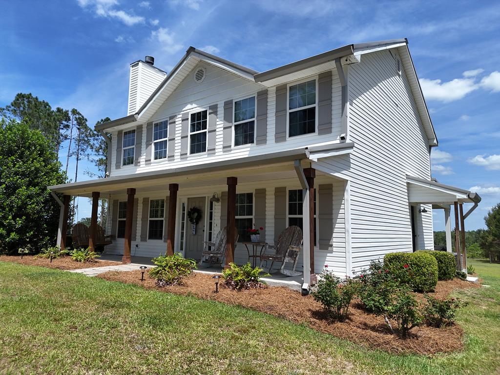 Tucked away on 5 beautiful acres surrounded by mature pines and stately oak trees, this charming two-story home offers a setting reminiscent of classic plantation grounds—peaceful, private, and picturesque. Inside, you'll find a well-designed layout featuring 3 bedrooms and 2.5 baths, with all bedrooms conveniently located upstairs for added privacy. The main level offers a welcoming flow, highlighted by a spacious kitchen with a large island—perfect for meal prep, entertaining, or gathering with family. The kitchen opens seamlessly into a bright breakfast area, creating a warm and functional everyday living space. Step outside to the covered back porch, where you'll want to spend your mornings enjoying coffee in the soft sunlight or unwind in the afternoons shaded by the surrounding trees. The natural beauty and tranquility of the property make this outdoor space truly special. If you've been looking for a home that combines charm, privacy, and a stunning natural setting—this is one you need to experience in person. Click here for virtual tour: https://my.matterport.com/show/?m=SbQnxdhKFEE&mls=1