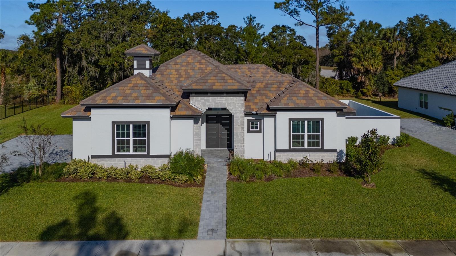 Luxury Has a New Price- and It's More Attainable Than Ever!!!! Welcome to this stunning courtyard-style contemporary home located in the well-established Toscana community by the highly respected ABD Development, thoughtfully positioned among lakes and conservation land to provide privacy and tranquility while remaining just minutes from everyday conveniences and approximately ten minutes from the beach, designed as a private oasis where the entry opens into a serene courtyard with a beautiful pool and spa, setting a resort-like tone from the moment you arrive, with wide sliding glass doors throughout the home creating a natural connection between indoor spaces and the courtyard, allowing the pool and outdoor living area to become a true extension of the home, especially in the evening when the pool is softly illuminated, offering an open Kitchen and Family Room combo designed to be both visually striking and highly functional, featuring an ultra-modern kitchen with sleek  high-gloss cabinetry that creates a bold contemporary statement, complemented by clean lines, refined finishes, well-appointed appliances, and built-in ceiling speakers allowing you to enjoy music while cooking or entertaining, with wide sliding doors fully opening to the courtyard to create an airy, open environment perfect for relaxed gatherings and everyday enjoyment, a private guest suite/cabana with full bath and sliding glass doors overlooking the pool ideal for guests, extended family, or a private home office, a true primary retreat featuring direct access to the courtyard through sliding glass doors, tray ceilings adding architectural depth and elegance, and a spa-inspired primary bathroom with a freestanding soaking tub, glass-enclosed shower, and quartz vanities that feels open, refined, and intentionally private, while the contemporary aesthetic continues throughout the home with clean architectural lines, tray ceilings, refined trim work, upgraded baseboards, a Level 4 smooth drywall finish with modern square corners, solid-core interior doors enhancing sound insulation and overall quality, an attached three-car garage, and a premium lot with no neighbors directly behind offering permanent wooded views and a tranquil natural backdrop, bringing together architecture, privacy, thoughtful design, quality construction, and a relaxed coastal lifestyle in one distinctive residence designed to be truly enjoyed and experienced.