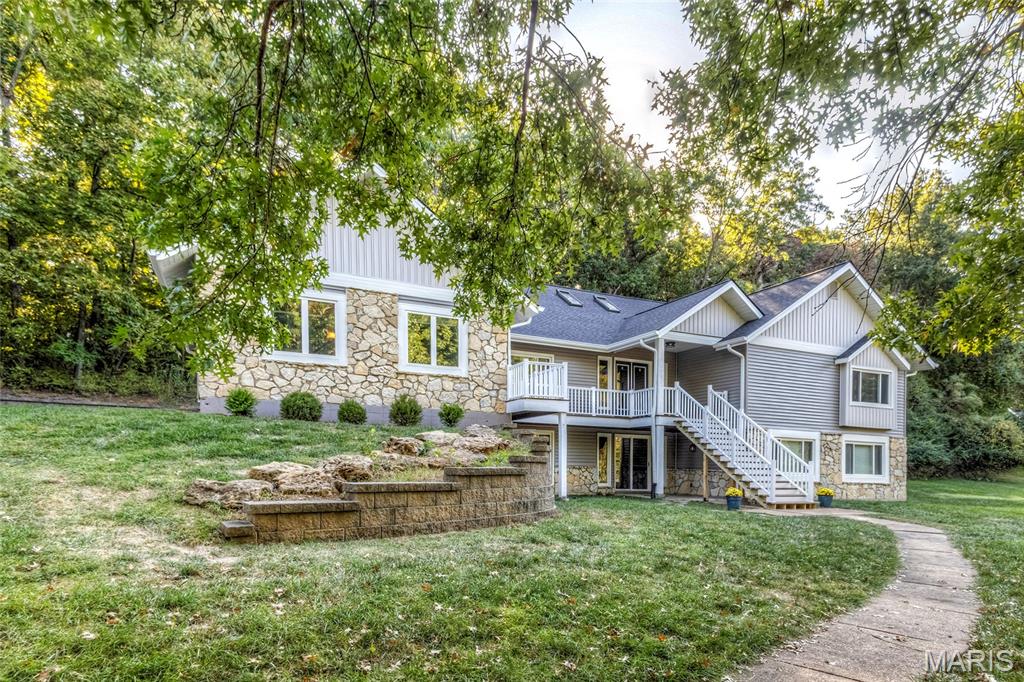 Nestled on a quiet cul-de-sac lot backing to mature trees, this gorgeous open-concept ranch offers the perfect blend of elegance, comfort, and natural beauty. From the moment you step inside, you’ll be captivated by the soaring vaulted ceilings, expansive wall of windows overlooking the peaceful wooded backyard, and light-filled living spaces.The impressive great room features a dramatic floor-to-ceiling brick fireplace, skylights that fill the space with natural light, and gleaming wood floors. Designed for both everyday living and entertaining, the gourmet kitchen boasts two oversized islands, stylish modern chandeliers, abundant cabinetry, a double oven, pantry, and beverage refrigerator. The adjoining breakfast room is surrounded by windows and offers direct access to the composite deck—an ideal spot for outdoor dining and entertaining.  The spacious primary suite features a large picture window framing serene wooded views and a beautifully updated luxury bath complete with a walk-in shower, elegant clawfoot soaking tub, and double vanity. A second generously sized bedroom with an en-suite bath and large closet, convenient main-floor laundry, and a half bath complete the main level. The open staircase leads to an expansive lower-level family room featuring another stunning brick fireplace, a wall of windows with a walkout door, crown molding, and recessed lighting. Three additional spacious bedrooms offer large picture windows, ample closet space, and ceiling fans, providing plenty of room for family, guests, or a home office.Additional highlights include a three-car garage, abundant lower-level storage, and a large, level side yard offering even more outdoor possibilities.  With its beautiful architectural details, spacious layout, abundant natural light, and tranquil wooded backdrop, this exceptional home offers a rare combination of style, space, and privacy.