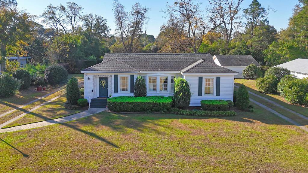 Move-in ready and filled with Southern charm, this beautifully maintained three-bedroom, two-bath home blends classic elegance with modern convenience. Featuring original hardwood floors, a formal living and dining room, a cozy den, and a bright kitchen with new stainless steel appliances, spacious cabinets, a pantry, and a sunny breakfast room, this home offers space and comfort for everyday living. Enjoy plantation shutters throughout, a convenient laundry room, and wonderful outdoor living with a screened-in back porch, large patio ideal for entertaining, and a stunning double lot with manicured landscaping and income-producing pecan trees. Additional features include a one-car detached garage, a workshop with half bath, and a circle driveway for easy access. Perfectly located between Cairo, Thomasville, and Albany, this property offers timeless character, modern updates, and unbeatable location—making it an exceptional real estate opportunity in South Georgia.