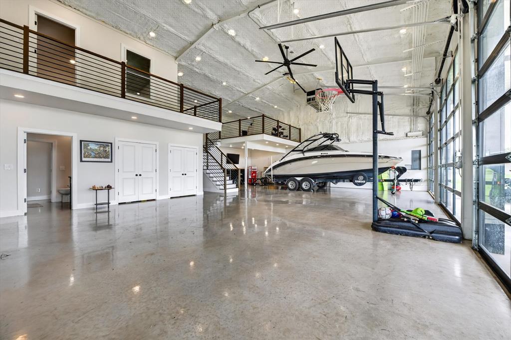 Experience modern luxury and expansive country living in this exceptional 3-bedroom barndominium situated on over 5 private, unincorporated acres in Ponder — no city taxes, no city codes, and no zoning ordinances. The land and structures are agriculturally exempt, keeping annual property taxes remarkably low. The interior features a sophisticated open-concept layout with polished concrete flooring, decorative lighting, and a chef's kitchen equipped with granite countertops, a central island, farm sink, and premium gas range. The primary suite is conveniently located on the first floor and boasts a custom closet system and an ensuite bath with a separate walk-in shower, while the second floor offers a versatile loft and second bedroom with built-in custom storage. Each bedroom is served by an independent ductless mini-split for zoned efficiency, alongside central HVAC in the main living area. Perfect for hobbyists or professionals, the property features a massive 3-car heated garage with an internal workshop including a dedicated shop bay with 6-inch reinforced concrete and 220V overhead plugs prepped for a 2-post vehicle lift plus an additional multi-car carport, providing covered parking for up to 8 vehicles with room for an RV or boat. The entire structure sits on a commercial-grade traditional rebar slab foundation. Water needs are more than covered with a 686-foot deep well sized for maximum allowable unmetered flow in Texas, feeding a 3,000-gallon above-ground storage tank with transfer pump for city-like pressure. A whole-home standby generator is sized to run current systems and a future dream home, and oversized utilities, water, gas, septic, and electrical subpanels are already pre-routed for a secondary home.Outside, enjoy a half-acre fenced pasture with animal shelter and water line, plus access to 15+ contiguous acres of neighboring pasture available for lease. Located within the highly regarded Denton ISD.