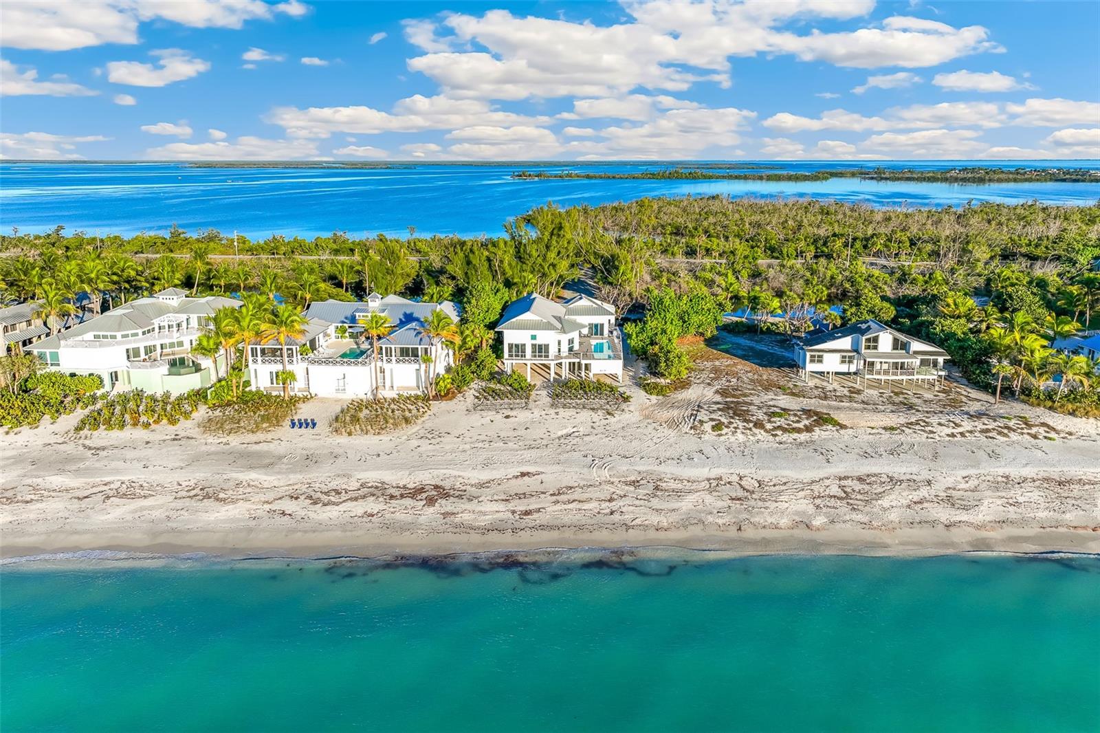 This elevated beachfront residence offers 105 feet of unobstructed Gulf frontage on a private lane with quick access to Boca Grande’s charming village. Expansive impact glass sliding doors open to the water views and illuminate the open living area, while the galley kitchen overlooks the pool and outdoor spaces. The primary suite features floor-to-ceiling doors, a small private office, and an ensuite bath. The two guest rooms feature large closets and full baths. Outside, the private pool and sun deck create a sunny retreat. Just a short golf cart ride away, enjoy Boca Grande’s boutiques, dining, and the historic Gasparilla Inn. Sold furnished, this beachfront property delivers the beachfront, island lifestyle.