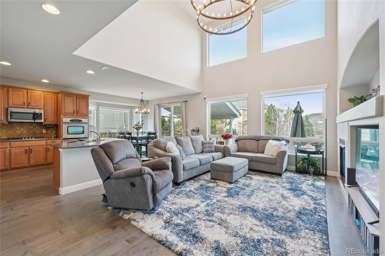 Experience the ultimate Colorado lifestyle in this stunning residence located in the prestigious Sapphire Point community of Castle Rock. A beautifully landscaped front yard and a welcoming covered porch lead you into the main level. Upon entry, you are greeted by a formal living room to your right and a sunny space to your left, perfect for a dedicated home office or a formal dining room. The heart of the home opens into a spectacular main living area where the living room boasts soaring ceilings and a cozy gas fireplace. The adjacent kitchen is a chef’s delight, featuring stainless steel appliances, durable Corian countertops, a central island with a breakfast bar, and a walk-in pantry. The dining area flows effortlessly through sliding glass doors to a large covered patio, offering a seamless indoor-outdoor transition for entertaining. The main level is thoughtfully completed with a convenient laundry room providing access to the attached 3-car garage, a half-bath, and a flex room. Retreat upstairs to the primary suite, a private sanctuary with high ceilings, a luxurious five-piece en-suite bath, and a generous walk-in closet. Three additional well-sized bedrooms and a full guest bath are also located on the upper floor. The basement offers a large bonus room and ample storage for all your seasonal gear. The outdoor living space is a true highlight, featuring a fully fenced backyard with professional landscaping, a spacious covered patio, and an additional uncovered patio to enjoy the sunshine in any season. Living in Sapphire Point means access to fantastic community amenities, including a pool and clubhouse. You are perfectly positioned near Philip S. Miller Park, a 320-acre outdoor playground with hiking and biking trails, a rec center, and Gemstone Park. Plus, world-class shopping is just minutes away at the Outlets at Castle Rock, and golf enthusiasts will appreciate the proximity to the renowned Castle Pines Golf Club.