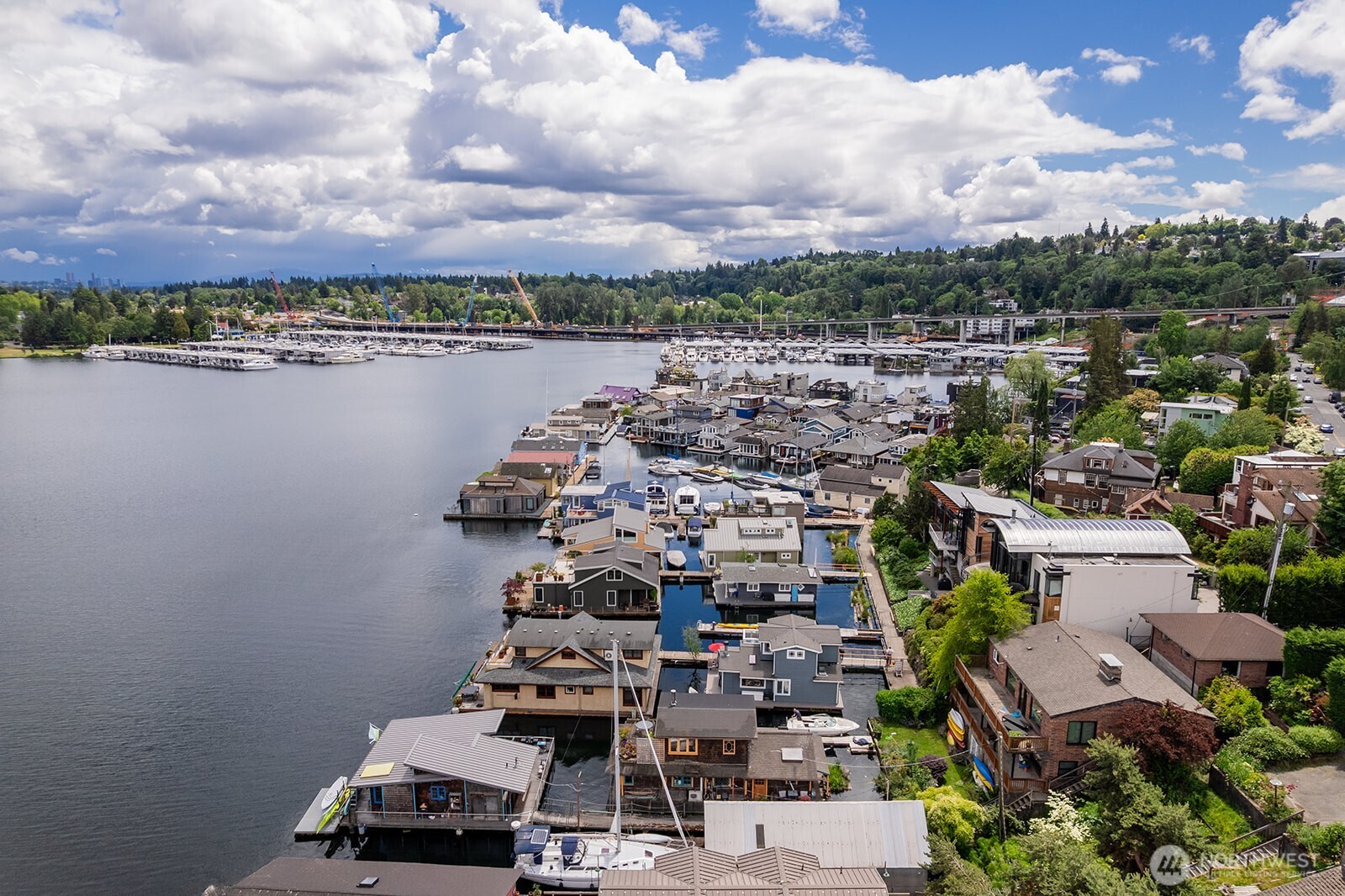 Fabulous floating home with the perks of living in a fantastic waterfront community! Beautiful Craftsman architectural details and a thoughtfully designed floor plan create a warm and inviting living space. The flexible main floor room is currently used as a media room but can easily serve as a bedroom, office, or guest space. The living room features a cozy wood-burning fireplace and large windows that frame beautiful views across Portage Bay and out toward the lake.  Upstairs is a spacious primary suite with a private en suite bath, creating a peaceful retreat above the water. A private view deck off the primary suite provides the perfect place to enjoy morning coffee while taking in the waterfront setting. Meticulously maintained and move-in ready, this home reflects pride of ownership throughout.  Enjoy the best of floating home living with view decks on both levels, offering ideal spaces for entertaining, relaxing, or simply watching boats glide by. Take in the scenery of living the floating home lifestyle out towards the lake while enjoying the way the light reflects off the water and the serenity of life on the water.  Parking and storage are included, making everyday living easy and convenient. A rare opportunity to enjoy city living paired with the peaceful beauty of a welcoming floating home community. Portage Bay is long sought after and this home is an easy yes.