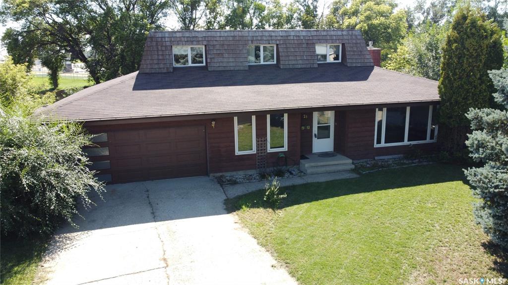 Tucked into a quiet cul-de-sac where traffic is rarer than a kid volunteering to do the dishes, this 2,228 sq. ft. home at 21 Hayward Place, Swift Current, SK, is a mix of comfort, charm, and thoughtful features. Its unique exterior design catches the eye before you even step inside, and once you do, bamboo hardwood floors stretch through much of the home, setting a warm and inviting tone. The kitchen is roomy and opens to the dedicated dining area as well as to the family room with its large natural gas fireplace feature — ideal for cozy evenings. The real showstopper might be the huge, heated sunroom, a bright year-round haven where you can grow plants, entertain friends, or simply sip your morning coffee while pretending to be outdoors without dealing with bugs or wind. The spa-like main bathroom features dual sinks, heated floors, and the bathtub dreams are made of – an Air Bubble tub that is heated for more leisurely soaks, has a built-in stereo to set the mood, and light therapy for therapeutic benefits. The main floor offers two bedrooms, including a primary suite with direct access to a covered, enclosed patio retreat that feels like a private escape. Upstairs, you’ll find two more bedrooms and a handy 3-piece bath, perfect for guests or children who appreciate having their own corner of the house. The sprawling yard offers endless possibilities for gardening, outdoor games, or bonfires on the custom-built pad. And for those who appreciate storage or need a place for every hobby, you get not one, but two garages — a 21x21 double attached and a 30x30 double detached heated built in 2018 with an overhead screen door that give it even more functionality. If you’ve been searching for a home that offers space to live, room to grow, and a few brag-worthy features, this one’s worth seeing in person — before someone else beats you to the keys.