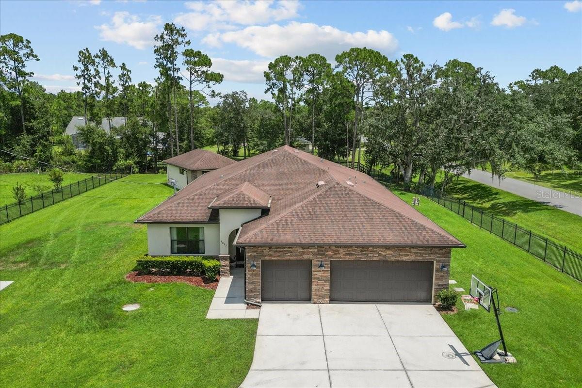 This extraordinary estate offers a seamless blend of elegance, functionality, and resort-style amenities..perfectly designed for entertaining and multi-generational living. Set on a gated, fully fenced acre, this property includes a 4-bedroom, 3-bath main residence plus a 1-bedroom, 1-bath guest house with a kitchenette, living room, and private entrance.

The chef’s kitchen is a culinary dream, featuring a large island with seating, a gas range, three ovens, oversized sink, and a massive butler’s pantry with counters, cabinets, wine fridge, and endless storage.   It opens to both the spacious living room and formal dining room, making it the perfect setup for gatherings.

The primary suite is a true retreat, offering direct access to the pool and spa. It features a spa-like ensuite with a double sink vanity, large frameless glass walk-in shower, and a huge 10’x12’ custom closet with built-ins. 

Bedroom 2 is versatile and stylish with coffered ceilings, double French doors, a bathroom with walk-in shower and frameless glass doors, and a 10' walk-in closet with built-in organizers, making it ideal as a guest room, home office, or gym. Bedrooms 3 and 4 are set apart from the main living area with a full bathroom between them, offering privacy for family or guests.

Step outside to an entertainer’s dream: a resort-style pool and spa, oversized paver patio, gas firepit, and patio lights that set the perfect mood for evening gatherings. Both the main and guest homes have their own covered lanais, and the extended driveway is perfect for guests, or RV/Boat parking.  

Additional features include a 3-car garage, large laundry room with full-size sink, closet organizers in every closet, a central vacuum system, and automatic gated entry for peace of mind.

This is the kind of home that doesn’t just check boxes...it redefines what home should be.