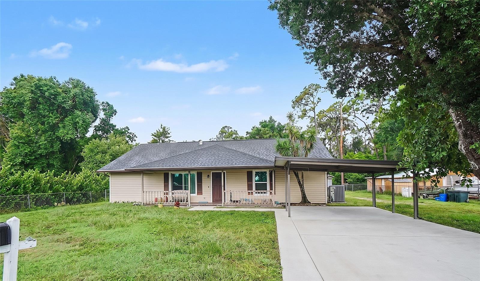 Virtually Staged. Sold as-is. 1425 Orchid Rd is a 5 bedroom, 2 bath single-family pool home with 2,135 square feet under air, built in 1986 on a 0.36 acre lot in North Fort Myers, Lee County, FL 33903.The system work is recent and was permitted through the county. New shingle roof installed within the last six months. High-impact windows installed in 2025. Central electric forced air HVAC, ducted, approximately three to four years old, with the condenser on a pad at the side of the house. Plumbing replaced. Electrical replaced, with recessed can lighting run through the main living areas. Well with a new pump, and septic on site. The floor plan is wide and open across two living areas. The front living room takes plank flooring, a ceiling fan and recessed lighting, and arched openings carry through to the dining space and on to the kitchen. At the back of the house the great room runs the full depth with a wall of glass and French doors out to the pool deck, which puts the pool in view from most of the main living space. The kitchen runs long. A galley run of shaker cabinetry sits under granite counters with a tiled backsplash, a gooseneck faucet, a stainless dishwasher and a double wall oven. A floor-to-ceiling pantry tower anchors the end of the run, and cabinet and counter space continues the full length of the room. Tile flooring, recessed lighting, and a door straight out to the rear yard. The primary bedroom sits under a vaulted ceiling with a floor-to-ceiling brick fireplace, a raised hearth and a mantel. Windows on two walls, a walk-in closet with double hanging rods and shelving, and a private bath with a soaking tub, a tiled surround, two windows and an extended vanity. Three more rooms give you bedrooms, a home office, a gym or a den, and one of them opens through its own French doors to the side yard. One is finished in wood paneling. The guest bath has a tub and shower combination with a tiled surround and a window. Interior laundry room with washer, dryer, upper cabinets and the water heater. Outside, the in-ground pool sits on a wide pebble deck with a tiled waterline and a stainless handrail, inside a chain link fenced yard. A detached garage and workshop building stands at the rear of the lot with a separate storage shed beside it. A two-car attached carport and a long concrete drive give you room for a truck, a boat or a trailer. Covered porch across the front of the house. The work left is cosmetic and defined: flooring to finish in a couple of rooms, a guest bath vanity, floor and toilet, one drywall patch left from the plumbing work, and a filter cartridge and barrier for the pool. Sold as-is, so what the photos show is what you get. North Fort Myers pool home in 33903, on well and septic, with a detached workshop, a fenced yard and the heavy system work already behind you.