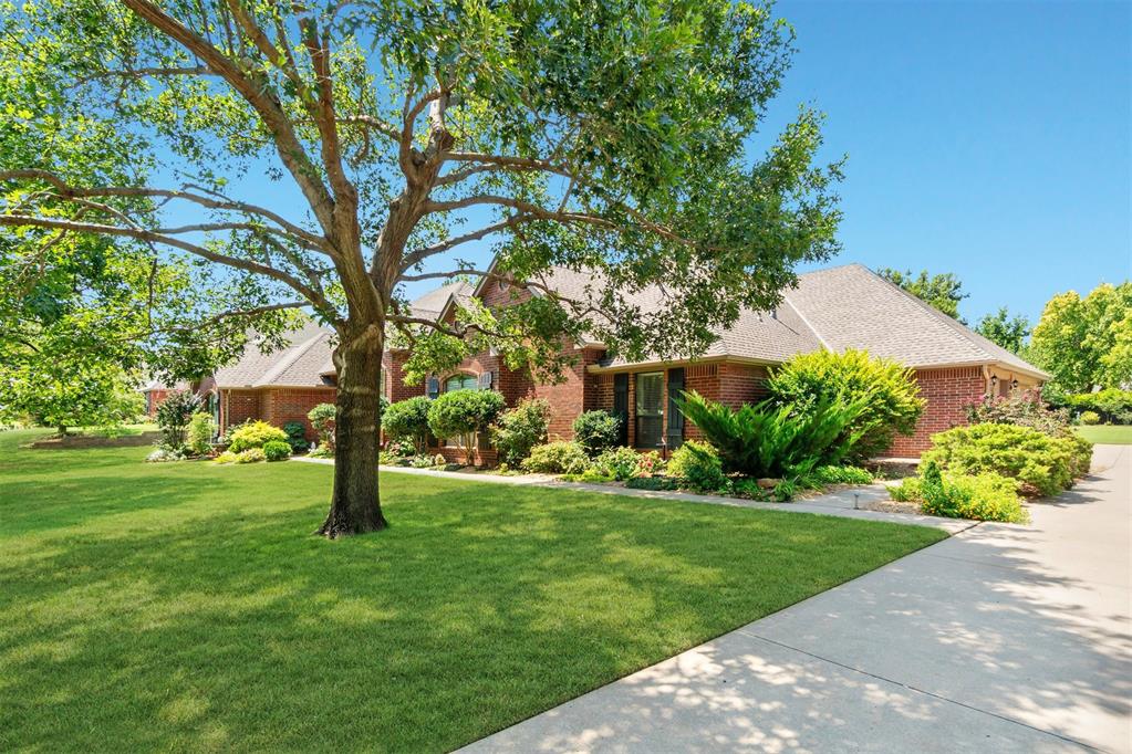 Luxury home in the gated Deer Creek Hills addition, custom built by Denise Patterson Homes as an “Executive Entertainment Home” on a spacious .70-acre lot. This home has been meticulously cared for & thoughtfully updated. The exterior has lush landscaping with seasonal blooms alongside a new roof (2024) & striking red brick façade. An oversized driveway provides ample parking, while large windows beautifully frame the front entry. Step inside to bright walls, newly installed wide-plank white oak engineered hardwood floors, and expansive windows showcasing the backyard views. The formal living room sets a welcoming tone, complemented by a formal dining room with a built-in wood hutch. Opposite the entry, a spacious study with French doors, built-in bookshelves, and wainscoting. The great room is filled with natural light & anchored by a gas fireplace with a wood mantle. The adjacent kitchen & dining nook overlook the backyard, with sealed brick paver flooring adding warmth and contrast to the modern white painted cabinets and new quartz countertops. The kitchen is equipped with new built-in double ovens, a gas range, refrigerator, pantry & storage. The primary suite is light and airy, with French door access to the back porch. Its updated ensuite features a soaking tub, sleek stand-alone shower with seamless glass surround, and marble-look tile flooring. A spacious walk-in closet includes built-ins & generous hanging space. 3 additional bedrooms offer ample storage with built-in shelving; two share a Jack-n-Jill bath while one enjoys a private ensuite. Guests will also appreciate 2 half baths. The laundry room is well-appointed with cabinetry, counters & a sink. In the garage, an above-ground storm shelter for 6–8 people. Additional upgrades include 2 new 50-gallon hot water tanks & 2 new HVAC units. Out back, the covered porch provides the perfect retreat for outdoor living spacious enough for furniture, a grill, and quiet relaxation with views across the property.