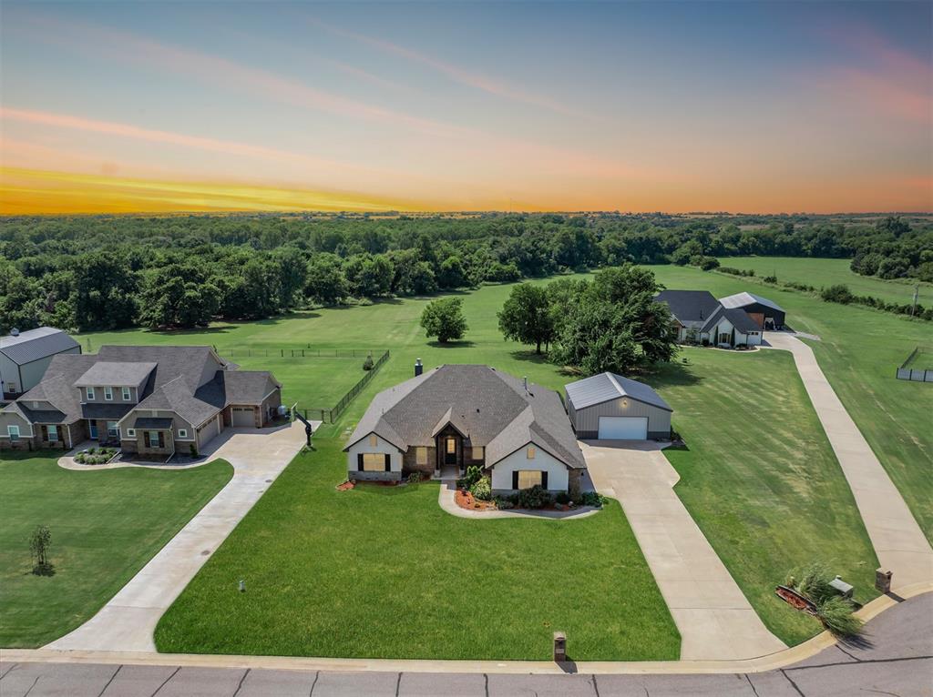 The complete package awaits in The Ridge—timeless architecture, modern updates, and undeniable style, all set on 2.35 acres with a shop. From the moment you arrive, the home makes a lasting impression with spacious covered porches, an on-trend exterior palette, and designer lighting. Inside, the living room is nothing short of a showpiece—soaring ceilings, expansive picture windows that flood the space with natural light, rich wood flooring, and a sleek corner gas fireplace that anchors the room with warmth and style. The kitchen is both functional and refined, designed for those who love to cook and entertain. Built-in stainless appliances—including a gas range and refrigerator—pair seamlessly with custom cabinetry, solid-surface countertops, and a central island with sink. A large pantry ensures ample storage for everyday essentials. Privately situated, the primary suite is a true retreat. Its spa-inspired bath showcases wood flooring, pristine cabinetry, quartz countertops, and a freestanding soaking tub as its stunning centerpiece—perfect for unwinding at the end of the day. Three additional bedrooms provide generous space for family or guests, offering comfort and flexibility to fit your lifestyle. Every detail has been thoughtfully considered—from the utility room with extra storage, to the in-garage safe room, sprinkler system, and tankless water heater—all combining convenience, efficiency, and peace of mind. Outdoors, enjoy the serenity of a large backyard. A private well and septic system provide added independence and value.. As part of The Ridge, residents enjoy a wealth of amenities including a community pool, playground, basketball courts, and even a baseball field. Located within the highly sought-after Deer Creek School District, this home offers both an exceptional lifestyle and an unbeatable location. Schedule your private showing today.