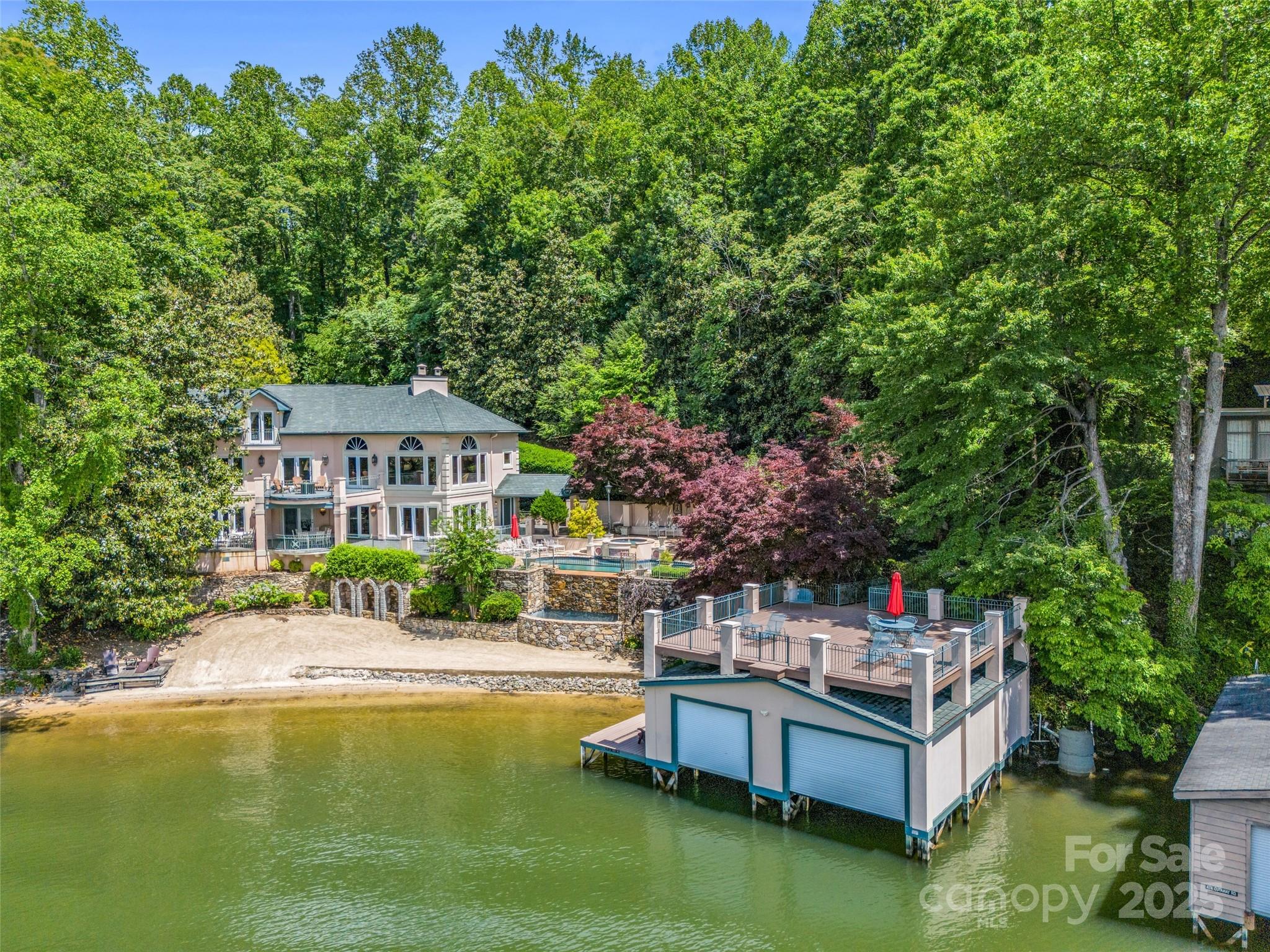 Welcome to Villa Rosa! This historic estate is renowned for its stunning architecture and picturesque
setting. Spanning over 4,500 square feet, this lakefront chateau offers five bedrooms suites each with its own recently upgraded bathroom. Featuring high-end fixtures, designer tilework, and spa-like finishes that bring a modern touch to the classic design. Inside, you'll find luxurious amenities including marble floors, intricate woodwork, and a gourmet chef’s kitchen. Enjoy panoramic lake views from multiple balconies and terraces. Outdoor amenities include a heated ionic infinity waterfall pool, private beach, and a fully remodeled double boathouse with an expansive waterfront deck. This estate is being offered fully turnkey and has proven to be a highly successful vacation rental. With direct lake access, refined entertaining spaces, and unmatched detail throughout, Villa Rosa is a rare opportunity to own one of Lake Lure’s most iconic and luxurious waterfront properties.