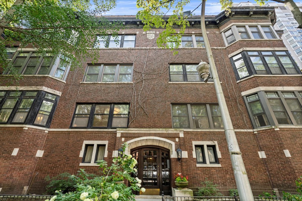 On a picturesque tree-lined block in Chicago's Buena Park, this sprawling 3-bedroom, 2-bathroom (plus sunroom!) residence is a rare 1920s gem and an extraordinary blend of history, elegance, and modern comfort. You'll open the front door and immediately feel the scale of this home. The foyer greets you with tall ceilings and gleaming oak hardwood floors. As you head into the oversized living room, you will notice custom built-ins, a cozy fireplace, Gilded Age style crown molding, and large windows overlooking Buena Avenue. A French door leads you into the sunroom. This is the ideal place for working, reading, or crafting. Enormous original windows bring in so much natural light, and shelving makes the perfect place for storage of all kinds. Back into the living room and down the hallway, you'll make your way to the kitchen and dining space. Don't forget to look up as you go. The ceiling was hand-painted by the current owner in the trompe l'oeil style. This is a design detail that is truly special and one-of-a-kind. In the kitchen and dining area, southern light pours in through a wall of windows. The kitchen is updated for today with crisp white cabinetry, marble backsplash, and striking countertops. There is a convenient pantry for additional storage, and it includes a hookup for installing a washer and dryer (there is also free laundry in the basement). The open-concept layout makes entertaining a breeze: in the extra-large dining room, you'll have room for a buffet, 6-10 person table, and then some. Before you tour the bedrooms, be sure to take the back stairs down to the sprawling shared back patio and garden. This is a quiet place to enjoy a meal, read a book, or soak up some sun. This home offers three bedrooms, all with deep closets. Two of the bedrooms have an en-suite bathroom, each decked out in floor-to-ceiling subway tile and Duravit fixtures. The third bedroom boasts beautiful built-in bookcases, and a surprisingly large walk-in closet. 703 West Buena is an all-brick walk-up (dating back to the 1920s) in the most desirable pocket of Buena Park. The timeless building has a commanding entryway, convenient for mail and deliveries, and a traditional staircase with spindles that takes you up to the homes. From this address, you're steps away from the enchanting Peace Garden that guides to quick access of the lake (the underpass is just down the street), Montrose Harbor, a swift 8 minute drive on LSD to downtown Michigan Avenue, and many CTA stops. For groceries, take a short walk to Whole Foods, Target, Jewel, Aldi, and the neighborhood farmers market. You couldn't be closer to restaurants and bars (try The Green Mill for live jazz), and coffee shops (Dollop is around the corner), gyms, parks, Brennemann School, Disney Magnet School, and so much more. Welcome home.
