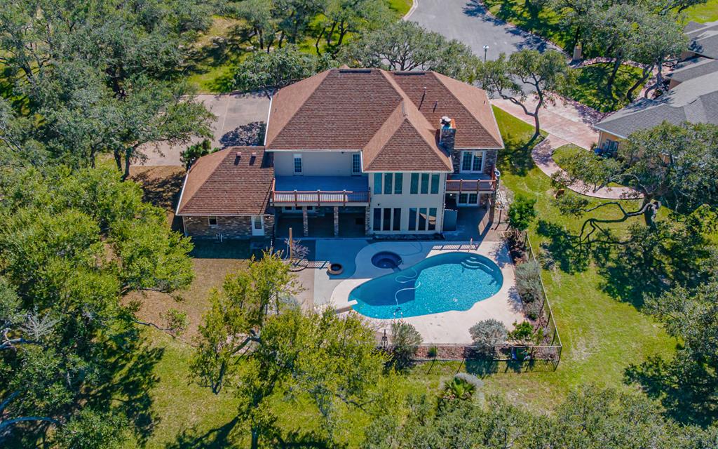 Big, bold, & busting with amenities. This is your opportunity to own a gorgeous Rockport Country Club Estate. The primary house overlooks the waterway onto the 14th. Enjoy summer days in the pool, hot tub or from one of the multiple porches. Inside you will find 5 oversized bedrooms, including two suites, 2 living rooms, formal dining and separated office. The downstairs suite encompasses a private flex room and even a sauna. The upstairs suite boasts a wood-burning fireplace, raised ceilings, and spectacular spa like bath. The additional bedrooms are spacious & offer ample closet and storage space. Relax after a day at the beach or on the course in your great room overlooking the water. The separated kitchen showcases an eating bar, island, loads of cabinets and counter-space and additional dining area. This home is packed with features you will want to see for yourself!