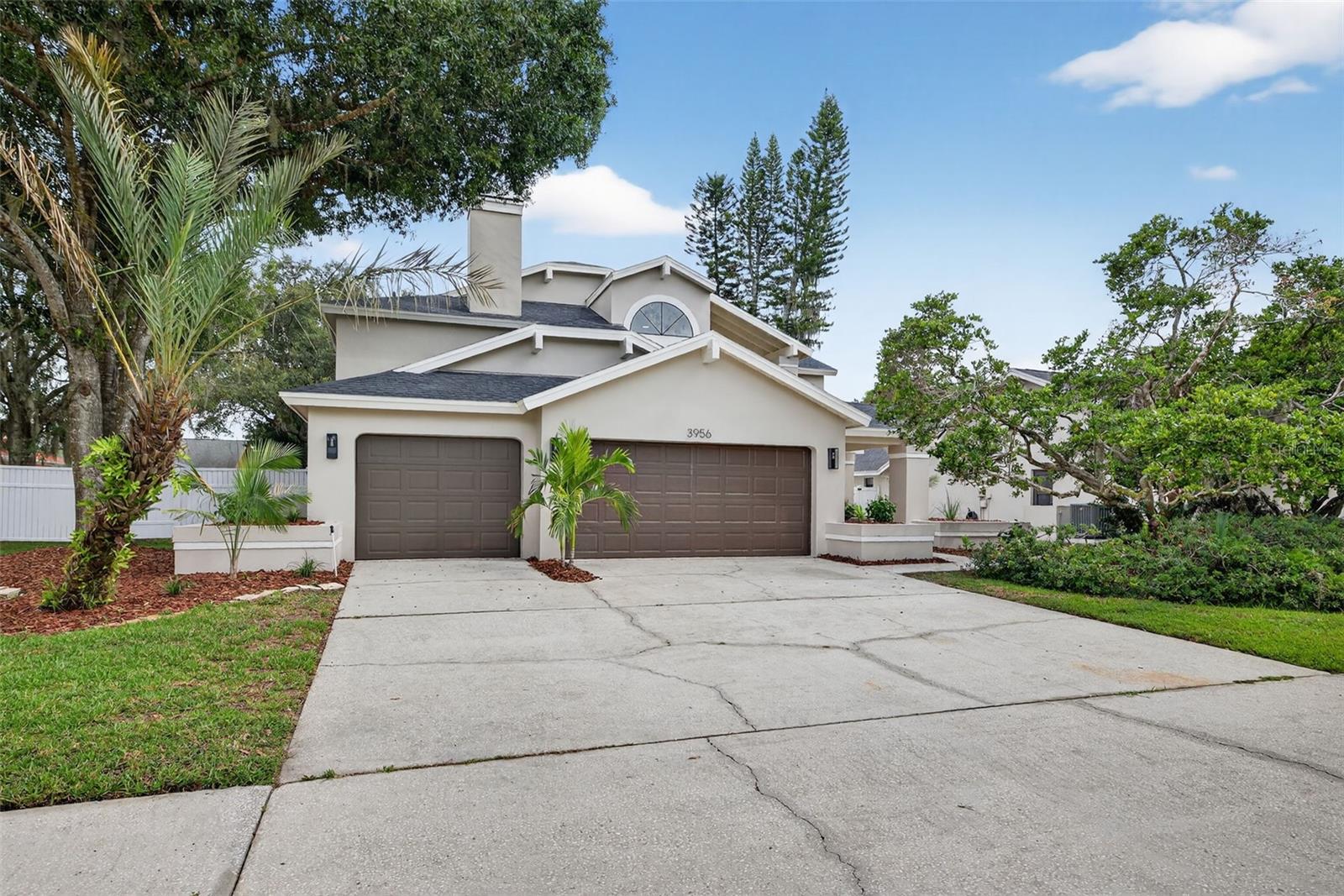 Imagine having the space to breathe--to be comfortable, spread out and truly live your best Florida life! That dream is a reality here at 3956 Belmoor Dr. in this sunny, GATED, Palm Harbor POOL HOME! This home has been meticulously designed with comfort, entertaining and style at every turn. Located on a generous fenced lot, over a quarter acre, this 4 bedroom, 3 bath home is thoughtfully designed with Scandinavian inspired touches and modern finishes. Stepping through the front door, you're immediately greeted by soaring two-story vaulted ceilings that let the natural light pour in. The spacious layout features engineered hardwood floors guiding you through an open and airy main level that flows easily from room to room. The formal living room is perfect for quiet evenings around the fireplace or hosting your favorites for mocktails around the bar. The newly renovated kitchen complete with soft close cabinets quartz countertops, crisp new appliances, double ovens, wall microwave and an island ready for snacks and conversation. Whether it's holiday baking marathons or weeknight dinners, this kitchen can handle it. Upstairs, the primary suite feels more like a private retreat. It’s oversized, with space for a sitting area or reading nook, and a walk-in closet you don’t have to compromise on. The ensuite bathroom is equally generous—an oversized soaking tub, separate shower, and dual vanities give everyone the room they need with all the luxury you're dreaming of. Imagine weekend mornings on the patio with coffee in hand, the yard stretching wide around you, and an in-ground pool just waiting to be enjoyed. It’s the kind of backyard that becomes the go-to gathering spot all summer long—grill going, music, and cooling off in your private pool complete with hot tub. The large fenced lot means there’s still space to run, garden, or let your furry friends frolic.  The three-car garage gives you plenty of room for cars, tools, bikes, and all the toys! All of this tucked inside a secure, gated neighborhood, near top schools, Honeymoon Island, Award winning beaches and hiking/biking trails. Come see for yourself what all the fuss is about--schedule your tour today!