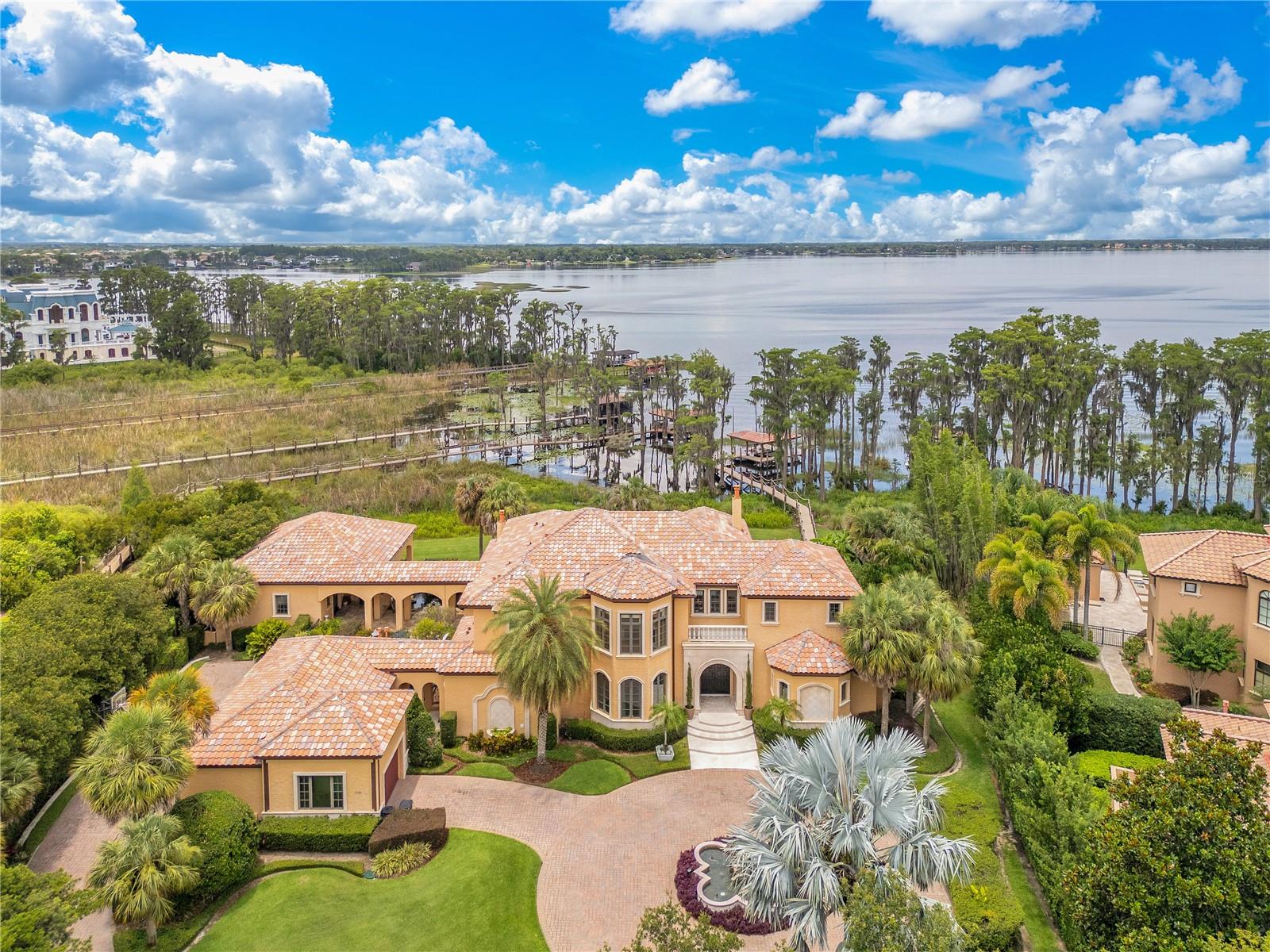 Step into timeless elegance, luxury, and sophisticated living. Located in the exclusive man-gated community of Lake Butler Sound—one of Central Florida’s most prestigious communities. From the moment you enter, you're greeted by high-end finishes, open-concept living space, and meticulous attention to detail. This stunning residence offers nearly 9,000 sqft of elevated living space featuring 5 spacious bedrooms, 8 luxurious bathrooms, and your very own private detached guest suite offering unparalleled comfort, perfect for having guests and upscale hosting. Enjoy cinematic experiences in your private movie theatre, with reclined seating, host unforgettable gatherings in the state-of-the-art entertainment center, and set the perfect ambiance with built-in speakers flowing music throughout the residence. This home is beautifully designed with an indoor-outdoor flow, making it an entertainer's dream. Step outside to a serene koi pond, lush landscaping, heated pool and your very own dock with direct water access to the Butler Chain of Lakes. This rare estate offers a combination of space, style, and status—a truly unmatched opportunity in Windermere.