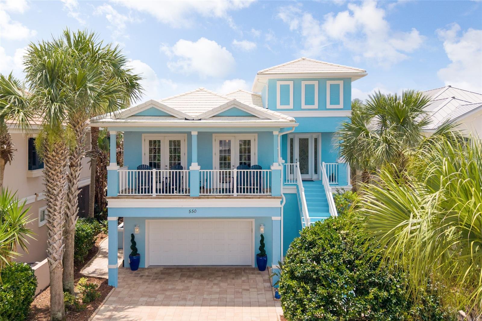 Under contract-accepting backup offers. Perfectly positioned just steps from the Atlantic Ocean within the exclusive gated community of Cinnamon Beach, this impeccably maintained coastal retreat offers the ideal blend of luxury, comfort, and investment potential. Nestled on a quiet cul-de-sac, this exceptional residence features 4 bedrooms, 3.5 bathrooms, and 3,297 square feet of thoughtfully designed living space. Fully furnished and completely turnkey, it is equally suited as a primary residence, second home, or income-producing vacation rental. Designed for effortless entertaining, the open-concept floor plan is filled with natural light and showcases soaring ceilings, custom wood tray ceilings, expansive living areas, wood-look tile flooring, and a dramatic floor-to-ceiling stone fireplace. The chef's kitchen is beautifully appointed with a Thermador gas cooktop, Bosch and KitchenAid stainless steel appliances, custom cabinetry, granite countertops, an oversized island with seating, and abundant storage. The spacious primary suite serves as a private retreat featuring a spa-inspired bath, custom walk-in closet system with a secure owner's cabinet, and an adjoining flex room ideal for a home office, fitness area, nursery, or hobby space. Custom built-ins throughout the home provide exceptional organization and functionality. The lower-level game room offers additional living space complete with a regulation-size air hockey table, retro arcade gaming machines, a full-size refrigerator, and direct access to the outdoor living area. Step outside to your own private oasis where the screened heated pool and spa overlook a tranquil lake, creating the perfect setting to relax and entertain year-round. The covered lanai features a fully equipped summer kitchen, while the expansive upper balcony provides a peaceful place to enjoy the water views and coastal breezes. Additional premium features include electric roller shades, plantation shutters throughout, newly installed exterior pathway and lanai lighting, a custom security camera system, a pre-installed Tesla EV charger, an oversized lockable storage room off the garage complete with a Liberty safe, an oversized paver driveway, and meticulous maintenance throughout. Offering luxury finishes, enhanced privacy, exceptional amenities, and an unbeatable beachside location, this remarkable Cinnamon Beach residence delivers the very best of Florida coastal living.