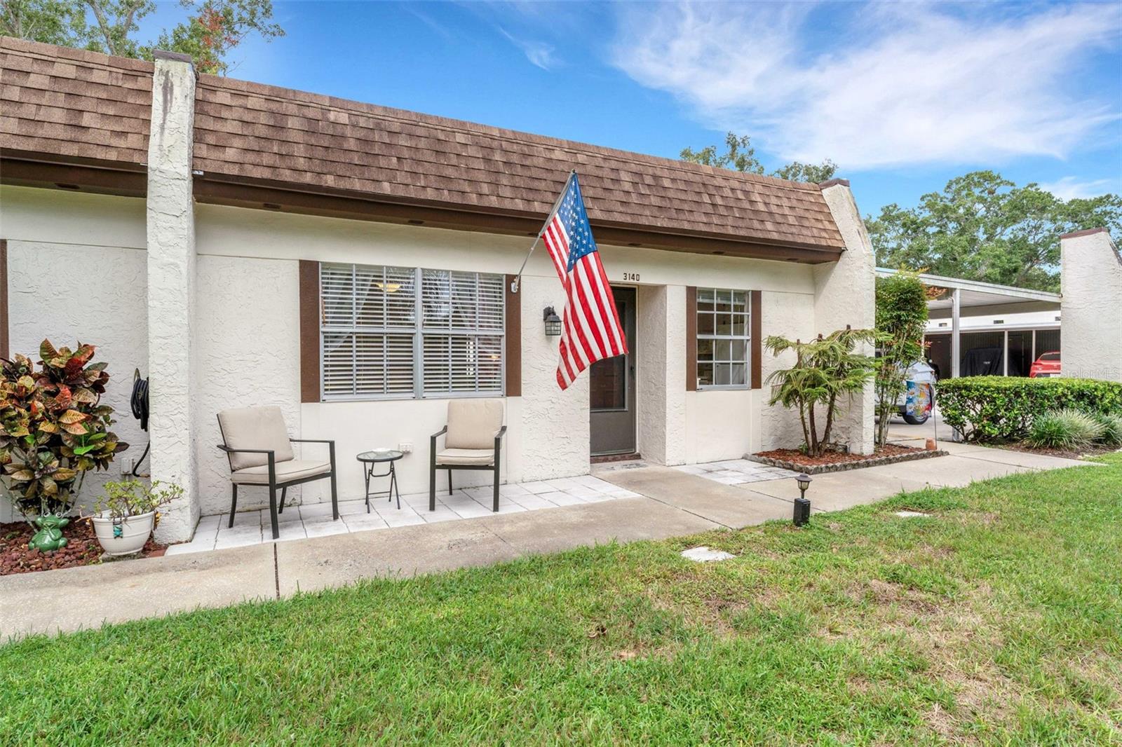This END UNIT with 2 BEDROOMS, 2 FULL BATHS condo that includes a COVERED CARPORT with STORAGE LOCKER (large enough for bikes, kayak, or decorations) PLUS a FLORIDA ROOM that looks over Green Space that extends your living space beyond the 866 sq ft under air.  The home features Light colored, wood-like Laminate flooring, AN INSIDE LAUNDRY CLOSET, plus a DISHWASHER and a BUILT-IN MICROWAVE in the kitchen. The kitchen with plenty of counter space and storage cabinets overlooks the Dining area and has a large window that brings in natural light. Updates also include a NEW ELECTRICAL PANEL in 2020, HVAC in 2019, New Ceiling Fans throughout, and it has been painted with pleasing, neutral colors that will go with any decor. Being Sold Furnished or Unfurnished. The Mission Grove Community has its own pool, shuffleboard,  pool pavilion, and laundry facilities. The $674 monthly HOA fee covers the building insurance, the roof, cable, internet, water, sewer, trash, and ground maintenance, giving you the freedom to come and go as you please. The $164 monthly HOA fee gives you the "BIG CLUB" with GOLF with NO GREEN FEES on 3 executive courses, FREE Boat or RV Storage on a secured lot, 2 Heated POOLS, Ceramics, Stained glass, Woodworking workshops, Card games, Board Games, Shows, 2 PONTOON boats for cruising Lake Tarpon, just to name a few. Highland Lakes on Lake Tarpon, where Relaxation and Recreation come together in this "55 or better" community. Convenient to shopping, quaint downtown Palm Harbor, the Beaches: Honeymoon Island, Sunset Beach, Fred Howard and Clearwater Beach, 2 International Airports, the perfect place for the full-time resident or a seasonal home.