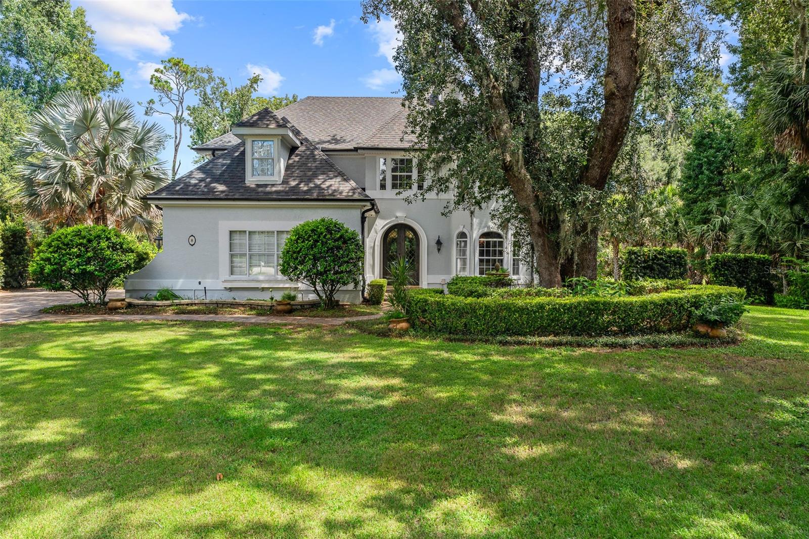 Old Florida charm meets modern luxury in this stunning estate home located in the sought-after Sugar Mill Plantation community, with easy access to beautiful downtown Flagler Beach. Surrounded by lush landscaping and majestic oaks, this residence offers both timeless elegance and contemporary comfort. Step through custom double steel entry doors into a dramatic two-story foyer with travertine floors and a grand chandelier. The formal dining room boasts rich Cypress wood floors, crown molding, custom trim work, and expansive windows overlooking a private side yard. The completely remodeled gourmet kitchen is a chef’s dream, featuring a Sub-Zero cabinet-front refrigerator, Wolf appliances, double oven, Cambria quartz countertops, gas range, two beverage fridges, built-in coffee/espresso system, and pantry closet. A charming breakfast nook with wood ceiling details, French doors, and large windows offers picturesque views and abundant natural light. The family room showcases travertine flooring, vanishing sliders to pool with electric shades, and additional access to the covered lanai through French’s doors. A private office with Cypress wood floors, custom built-ins and bay window for your private workspace. Downstairs completed with custom grand half bath perfect for guests, and picture-perfect laundry room with cabinetry, sink, and outdoor access. Upstairs, the primary suite features vaulted ceilings, Cypress wood floors, French doors to a private tiled balcony overlooking the preserve, custom walk-in closet, and a renovated spa bath with clawfoot tub, dual quartz vanities, linen tower, and walk-in tile shower. Bedroom 2 is set up like a junior suite- a spacious guest suite with bay window, crown molding, ensuite bath with soaking tub and walk-in showers, Plus another oversized bedroom 2 with wood floors, walk-in closet, and serene views. Additional bathroom 3 upstairs with tile tub/shower. All bedrooms upstairs, grand in size and private. The outdoor living space is an entertainer’s paradise with an electric heated pool, travertine decking, outdoor shower, fenced yard, and complete privacy surrounded by mature trees. Anchored on the end of the cul-de-sac with preserve tree lines. Additional highlights include: NEW ROOF 2024, 2-car garage with Shark coating floors, Whole-house water filtration system, under stair wine storage and additional upstairs storage closet, Crestron smart home automation (audio, lighting, blinds, garage, security cameras), Landscape lighting & irrigation system, Whole-house generator plug, 90-gallon hybrid hot water heater (2024), Septic serviced June 2025. With Cypress wood floors, travertine tile, Cambria quartz countertops, and custom crown molding throughout, this home blends refined craftsmanship with modern upgrades. Sugar Mill Plantation is renowned for its tranquil streets lined with sweeping oaks, offering a true Old Florida setting, just minutes from Flagler Beach’s shops, restaurants, and sandy shoreline.  Experience timeless Old Florida charm blended with modern luxury in one of Flagler Beach’s most beautiful communities—this home truly has it all.