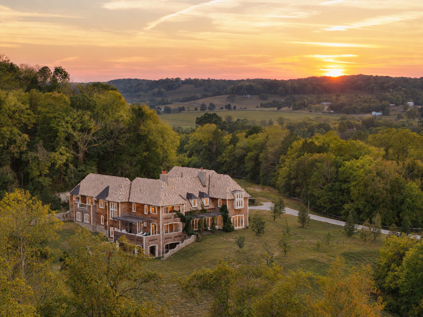 Leipers Fork Ranch: One of the most special offerings ever to hit the area. 122.51 acres within walking distance of Leipers Fork Village, with a 13,680 SF residence built by master artisans and seamlessly blended with a fully developed equestrian and agricultural landscape. The result is extraordinary. Throughout the residence, craftsmanship, exquisite materials, and design have been given equal importance, resulting in a home that is both highly sophisticated and deeply personal. Among its numerous custom features are 34’ curved-beam ceilings, a replicated Met Opera J & L Lobmeyr chandelier, two 34’ French limestone fireplaces, a 16’ Copacabana granite-topped brass bar, a 60-inch custom L’Atelier Paris brass range, an 11-ft Tiffany Quartzite kitchen island, a full catering kitchen, Savant AV...the list goes on. The study is a marvel with leather floors, marble fireplace, and storied wood walls - opening to a wraparound covered porch. Six bedrooms upstairs include the primary suite, with a sitting area, balcony, and an exceptional bathroom featuring Pink Crystal Agate countertops and a statement Maison Valentina soaking tub. The lower level offers a 14-seat theater, wet bar, pool table room, full bath, sauna, extensive conditioned storage, and secure storm shelter.  Other features include a temperature-controlled wine room, wine tasting/poker room, and four-car garage.The grounds include a stunning 10-stall main barn, a pony barn, a hay barn, and a 100’ x 50’ workshop or car barn - plus 13 pastures, 10 run-in sheds, two riding arenas, a chicken coop and pasture, trails, a pond, and beautiful Leipers Creek running through the land. This artistic equestrian estate is nearly impossible to duplicate with its intricate detail, amenities, land, and location. Charming and creative Leipers Fork Village — with its galleries, restaurants, shops, and live music sits just beyond the gate to your own magical oasis. Leipers Fork Ranch is as rare an offering as they get.