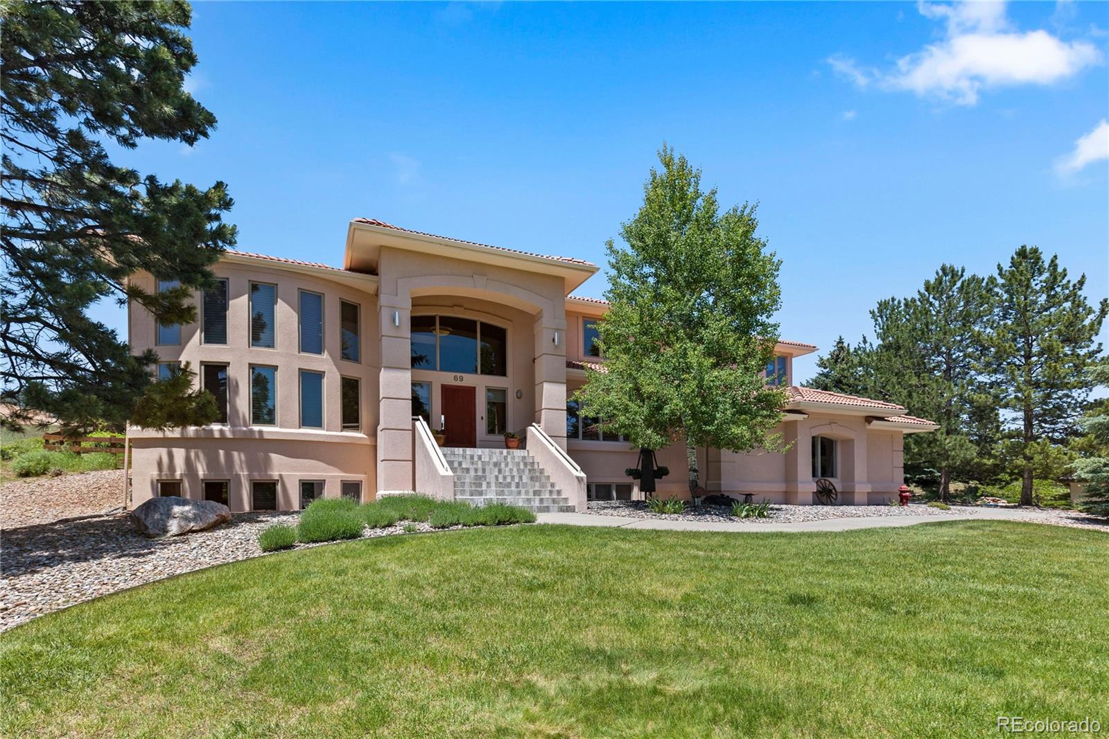 Welcome to your dream home nestled in the prestigious North Ranch at Ken Caryl community. This exquisite custom-built residence boasts 5 bedrooms and 5 bathrooms, perfectly situated on a sprawling 3/4 acre lot with incredible views throughout the property. Designed for luxury living and year around entertaining, the home features soaring high ceilings and an abundance of natural light that accentuates the open and spacious floor plan. The heart of the home is the gourmet kitchen, equipped with top-of-the-line appliances including a built-in fridge, new Kitchen Aid commercial-style oven and microwave, a gas cooktop, and a large center island, making it an ideal space for both intimate gatherings and lavish entertaining. The adjacent dining and living areas are seamlessly integrated, offering a harmonious flow for everyday living. The luxurious master suite is a private oasis with it’s own walkout deck and a cozy gas fireplace, complete with a stunning spa-like ensuite bathroom that includes a spacious walk-in shower, free standing soaking tub, double vanity sinks, and walk-in closet complete with custom built closet system. Additional bedrooms are thoughtfully configured, offering comfort and privacy for family members or guests. The basement offers several standout features of which include nine to ten foot ceilings, a theater room, two additional bedrooms, a full bathroom, PLUS a fully functional recording studio, perfect for music enthusiasts or professionals seeking a creative space from the comfort of home. Whether you're recording your next album or indulging in your musical passion, this studio is designed to inspire. Step outside to enjoy the beautifully landscaped grounds, offering ample space for outdoor activities and incredible views of Red Rocks and the surrounding area. The tranquil setting provides a serene escape while still being conveniently located just minutes away from shopping and tons of great restaurants. Schedule your private tour today!