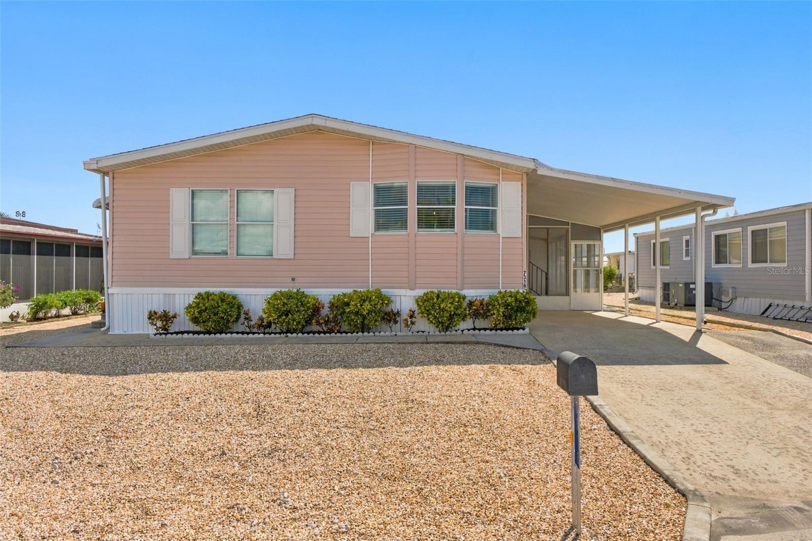 Welcome home to Ponderosa Park, be blown away by this inviting 2-bedroom, 2-bath home offering an open floor plan, abundant natural light, and comfortable living in an active 55+ community. Step inside to LVP flooring (2020), soaring ceilings, and a versatile entry area with the perfect potential for a mudroom. The spacious living room flows seamlessly into a dining nook and an updated kitchen featuring newer white shaker cabinetry, stainless steel appliances, granite countertops, and a bay-style window that fills the space with natural light. Privately situated at the rear of the home, the owner's suite features high ceilings, a wall-to-wall closet, and an en-suite bathroom with a shower, linen closet, and plenty of natural light. The additional bedroom provides flexibility for guests, hobbies, or a home office. The second bathroom offers a shower/tub combination and an updated vanity with granite countertops. An interior laundry area adds everyday convenience. Enjoy relaxing outdoors in the covered, screened lanai with sliding windows. The one-car carport includes a storage shed, while the extended driveway provides additional parking. Other great features? The roof was redone in 2020, and the AC was recently updated in 2024 (with a transferrable warranty) and there is a ring doorbell for added security! Low-maintenance landscaping with decorative rock helps minimize yard upkeep. Ponderosa Park offers a community lifestyle with a recreation center, swimming pool, shuffleboard, entertainment venues, and a variety of social activities— including fish fries, pancake breakfasts, ice cream socials, and holiday gatherings such as Thanksgiving and Christmas dinners. The Ladies Auxiliary adds another opportunity for community involvement. Enjoy comfortable living, functional spaces, and community amenities in this Hudson 55+ park with a low $250/ year HOA!