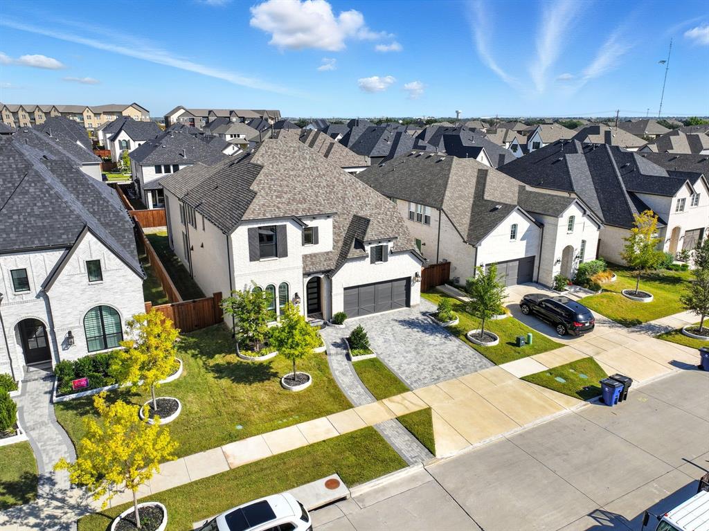 Welcome to a luxurious Highland Home in The Grove, Frisco’s premier master-planned community, perfectly situated at the crossroads of Plano, Allen, McKinney, and Frisco. This 5-bedroom, 5.5-bath masterpiece, built just 2 years ago, boasts over $200K in designer upgrades, blending sophistication with functionality in a highly sought-after floor plan. Step through the grand double-door entry into a stunning two-story foyer, leading to a private study with French doors and built-in cabinetry, ideal for work-from-home needs. The heart of the home is a gourmet chef’s kitchen, featuring an oversized island, double ovens, upgraded appliances, and designer lighting—perfect for entertaining or family gatherings. The family room, with soaring ceilings and a floor-to-ceiling tiled fireplace, exudes grandeur. The primary suite is a serene retreat with a spa-inspired ensuite, freestanding soaking tub, double vanity, custom built-ins, and a spacious walk-in closet. A private guest suite with a full ensuite on the main level ensures comfort and privacy. Upstairs, three additional ensuite bedrooms, a versatile game room, and built-in desks offer luxury and practicality. The downstairs media room is perfect for movie nights, and the 3-car tandem garage provides ample storage. Located minutes from Frisco’s top attractions, including the future Universal Studios, PGA Headquarters, upcoming Kalahari Water Resort, and Costco near HWY 121, this home offers unmatched convenience with easy access to HWY 121, Dallas North Tollway, and HWY 75. Don’t miss this rare opportunity to own a model-like home in one of Frisco’s most coveted neighborhoods. Schedule your tour today! PLEASE ASK ABOUT OUR BUYER CREDIT TO BUY DOWN YOUR MORTGAGE RATE.