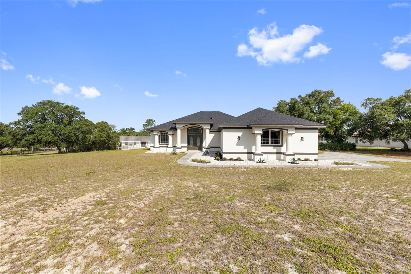Welcome to your private slice of country living — where modern upgrades meet wide-open space on a beautifully refreshed 1.1-acre property with NO HOA and NO CDD fees. Built in 1999, this thoughtfully updated home offers the perfect blend of comfort, functionality, and freedom. Step inside to discover an expansive open-concept layout featuring brand-new porcelain flooring throughout, fresh interior and exterior paint, and stylish new lighting that brightens every room. The spacious living and dining areas flow seamlessly into the completely remodeled kitchen, showcasing all-new appliances, modern finishes, abundant cabinetry, and a layout ideal for both everyday living and entertaining. The split-bedroom floor plan provides privacy and flexibility, with a generously sized primary suite featuring dual walk-in closets and a beautifully renovated primary bath. Additional bedrooms are spacious and inviting, while all bathrooms have been fully updated with contemporary finishes and fixtures. Enjoy peaceful mornings and relaxing evenings from the oversized covered patio overlooking the large backyard and open acreage. The property also includes spacious chicken coops, making it perfect for hobby farming, homesteading, or simply enjoying a more self-sufficient lifestyle. Additional highlights include: New Roof! Oversized Garage! Large laundry room and pantry! Fresh modern upgrades throughout! Expansive outdoor living space! 1.1 acres with room to grow, play, or store your toys. If you’ve been searching for a move-in-ready home with land, privacy, and high-end updates — without restrictive community fees — this property delivers the lifestyle you’ve been waiting for. Call now to schedule your appointment and make it your own today!!