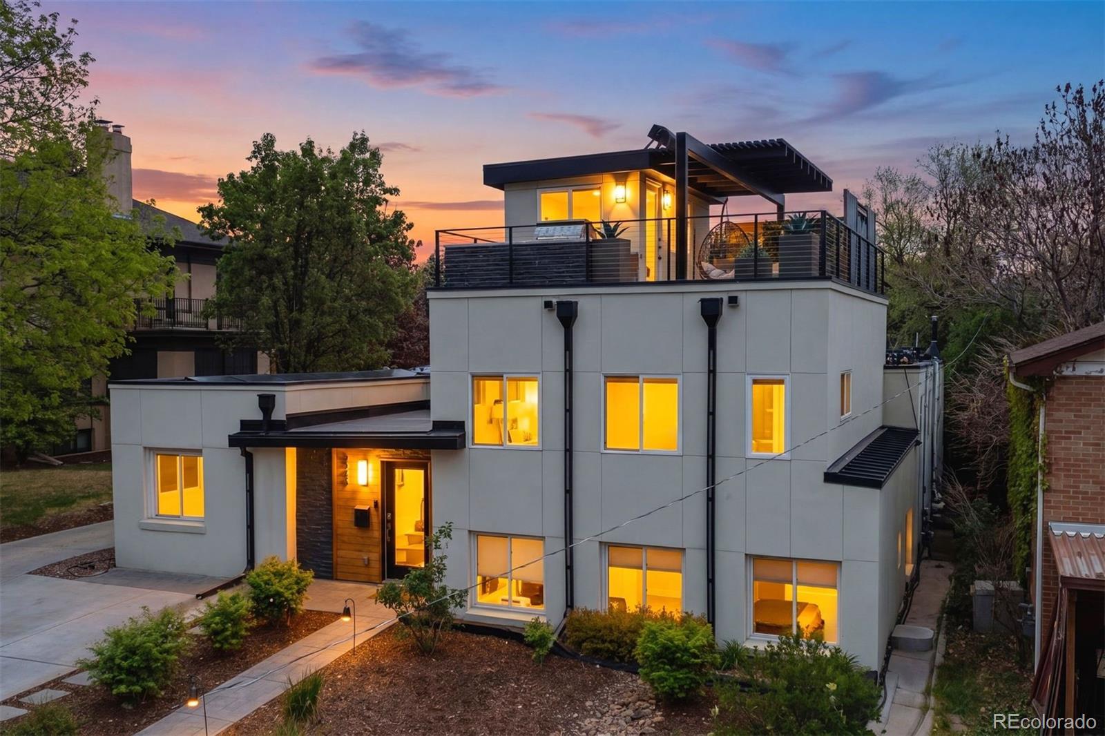 Sophisticated modern design defines this exceptional South Park Hill residence. Thoughtfully expanded and remodeled, this 4-bedroom, 3-bath home blends clean contemporary lines with warm, inviting spaces tailored for both everyday living and elevated entertaining.  A custom-designed mudroom welcomes you with stylish functionality and ample storage for every Colorado season. Sunlit main level unfolds into an open-concept living and dining space anchored by a gourmet kitchen.  The primary suite offers a spacious walk-in closet and spa-inspired bath complete with an oversized shower. Two additional bedrooms are near a beautifully appointed bath and oversized laundry room. A versatile garden-level bedroom with en suite bath provides flexibility as a secondary primary suite, guest retreat, or work-from-home space. Just beyond the kitchen, tranquil formal and outdoor dining areas create a true sense of retreat, surrounded by a private fenced backyard featuring built-in seating, built-in grill, raised garden bed, custom barrel sauna and access to the 2 car, oversized garage. An elevated family room adds exceptional versatility with bench seating, and striking stairs leading to the rooftop patio. Enjoy sweeping mountain views, glowing Colorado sunsets, rooftop grilling, and relaxed evenings under the sky. Distinctive details throughout include curated murals by local mural artist, custom metal work, heated flooring, owned solar, newer windows, furnace, and tankless hot water heater, custom shades, EV charger, rooftop grill and cooler, washer and dryer, and more.  Positioned in the highly sought-after Park Hill Elementary School boundary and moments from neighborhood cafés, shops, and parks; plus convenient access to City Park, Denver Zoo, Museum of Nature & Science and Downtown Denver. A rare offering delivering architectural style, thoughtful functionality, and a peaceful urban lifestyle in one of Denver’s most beloved neighborhoods.