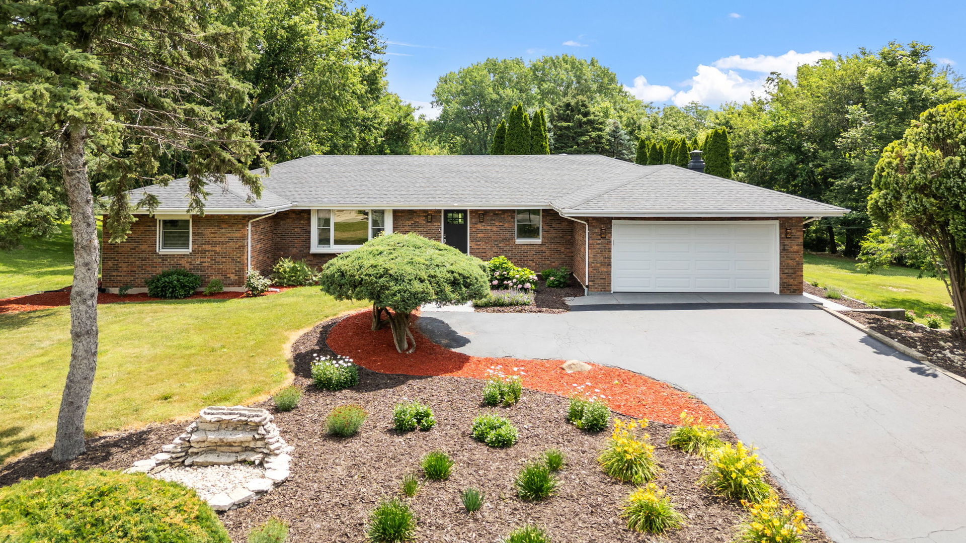 Incredible all brick ranch nestled on a meticulously maintained, 2.75 acre CREEKSIDE lot in Unincorporated Elwood. This breathtaking backyard is truly one of a kind between the mature trees, open green space, a peaceful creek running alongside, plus an additional detached 2-car garage. Inside, you'll find 3 bedrooms and 2.5 bathrooms on the main level; plus a full, finished basement completed with the 4th bedroom and additional full bathroom - ideal for related living or if you're a frequent host. The custom kitchen boasts new appliances, granite countertops, abundant cabinetry, and a large eat-in island. A cozy gas fireplace and views of the beautiful yard give this kitchen the absolute perfect touch. The primary suite includes a private bathroom with a walk-in tiled shower.  Laundry room is conveniently located on the main level. The full, finished basement offers storage and endless flex space for entertaining, working or relaxing. Don't miss the opportunity to enjoy peaceful, private living (with low taxes) while having the convenience of Manhattan right down the road!