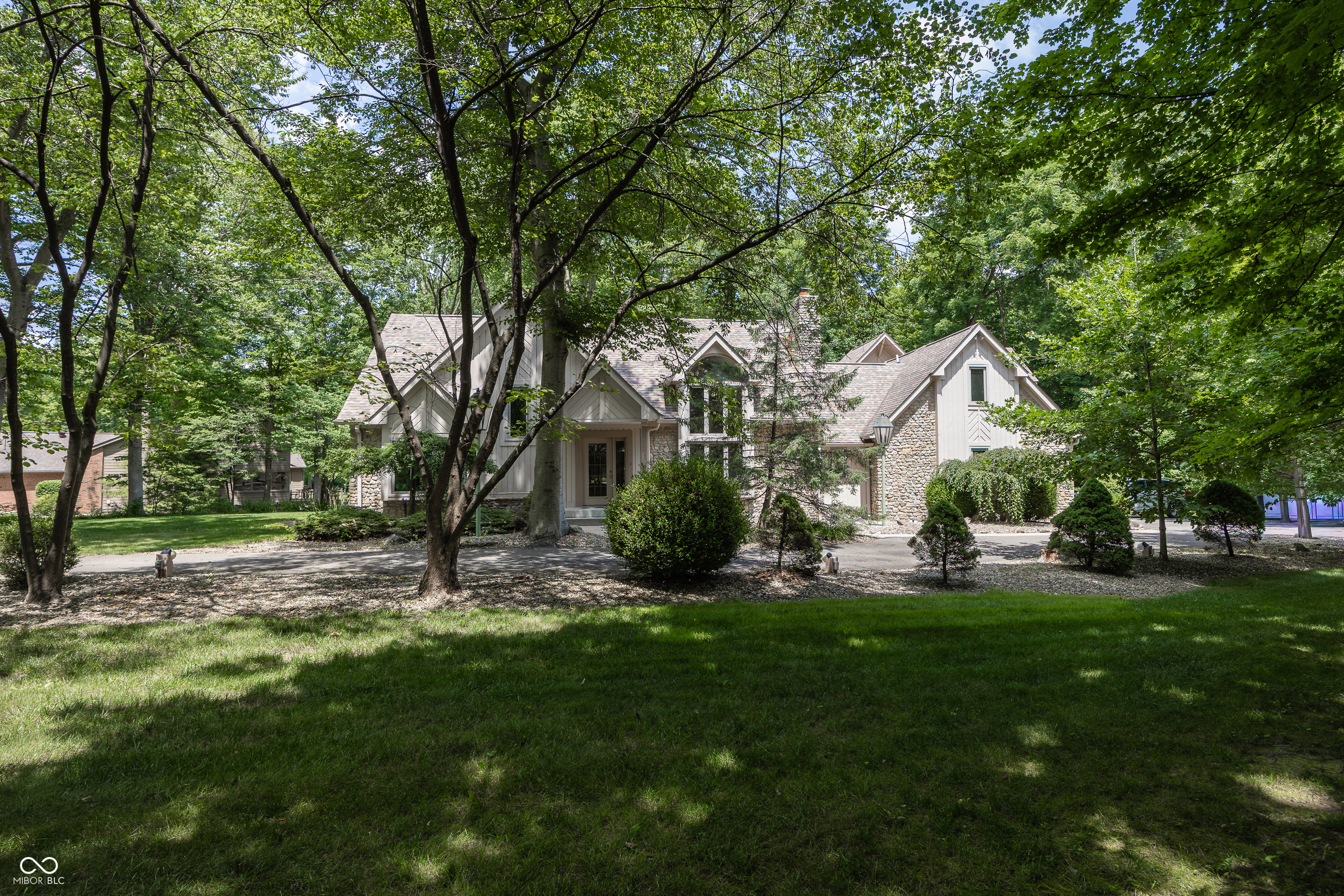 Meticulously maintained and thoughtfully designed, this custom-built 4-bedroom home offers peaceful living adjacent to Ironwood Golf Course, just off 106th Street in Fishers. Set on approximately .70 acres, the property provides a mature tree-lined setting, generous space between neighboring homes, and a private feel that is increasingly hard to find.    The main level features a desirable primary suite and an open-concept layout designed for both everyday comfort and entertaining. A spacious great room with soaring ceilings flows seamlessly into the kitchen and out to the deck, creating an inviting space for large gatherings. Beneath the second story, you'll find an additional flexible living area complete with a screened-in porch-ideal for relaxing, hosting guests, or enjoying the peaceful surroundings.    Upstairs offers a wonderful surprise with separate living quarters, two additional bedrooms, and added flexibility for guests, multigenerational living, a home office, or private retreat space. The expansive driveway provides ample parking for visitors and entertaining.    From its carefully positioned homesite to its functional floor plan and custom features throughout, this home was designed with comfortable, easy living in mind-all in a highly desirable Fishers location near Ironwood Golf Course.