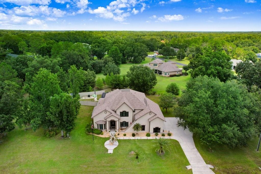 Under contract-accepting backup offers. Elegant Two-Story Pool Home on 1.88 Acres in Westwood Estates. Nestled within the gated equestrian community of Westwood Estates, this stunning 3,802 sq. ft. residence offers the perfect blend of luxury, functionality, and serene Florida living. Situated on nearly 2 acres, this 4-bedroom, 3.5-bath home features an office/library, a bonus/media room, and an oversized 3-car side-load garage. Step outside to your private backyard oasis, complete with a self-cleaning saltwater PebbleTec pool featuring a sun shelf and rock waterfall. The screened brick paver patio offers two covered areas ideal for entertaining, while a child safety fence, newly installed partial perimeter fence with solar lighting, and a storage shed add comfort and convenience. Inside, a dramatic two-story foyer welcomes you with a new modern chandelier, elegant crown molding, and tile accents. The formal living and dining rooms showcase double tray ceilings, while the spacious family room offers peaceful pool views. The gourmet kitchen is equipped with custom maple cabinetry, granite countertops, a stylish tile backsplash, ample pantry space, and upgraded Samsung black stainless steel appliances. A convenient first-floor bedroom with an en-suite bath makes a perfect guest or in-law suite. Additional main-floor highlights include a half bath, mini mudroom, and an oversized laundry room complete with washer/dryer, utility sink, and a second refrigerator. Durable Pergo plank and tile flooring flow seamlessly throughout the main living areas. Upstairs, the luxurious owner’s suite features a tray ceiling, cozy fireplace, generous walk-in closet, and a spa-style bath with dual vanities, a claw foot tub, and a dual-head walk-in shower. Two additional bedrooms each feature walk-in closets and share a full bath—one even includes a bonus room perfect for a playroom or home office. The windowless media room is ideal for a private theater setup. Notable updates include a newer roof (2022) and all new impact-rated Andersen Cat 3 windows. Don't miss the opportunity to own this extraordinary home—schedule your private showing today!