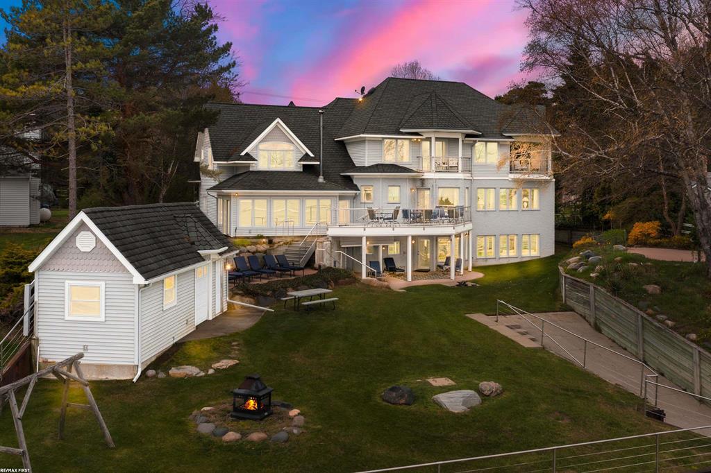 Discover this stunning lakeside retreat just minutes north of Lexington, nestled on an estate-like property along the shores of Lake Huron. Adding to its value, the detached carriage house is complete with additional bedrooms, a full bathroom and expansive 4 car garage/game room combination with epoxy floors, and upper loft. The paver walkway leads you inside the main house where you'll find an open concept kitchen with ample counter space, granite countertops, roll out shelves, and all appliances included. The island offers barstool seating for easy hosting. For more formal gatherings, enjoy time with friends and family in the formal dining room. The bright and airy great room is complete with a cozy gas fireplace, hardwood floors, and loads of windows with natural sunlight and stunning views of the lake. A private attached suite offers additional living space, with a primary bedroom ensuite, secondary kitchen, laundry, and natural wood burning stove. The handicap accessible elevator serves all three levels for added convenience. The primary bedroom screams luxury with access to a private balcony and large bathroom with timeless crown molding, dual sinks, and 2nd floor laundry. 2 additional ensuite bedrooms are located upstairs, along with a flex room or additional bedroom option. The walk out basement is the perfect setting for the beautiful summer months, featuring a full kitchen, full bathroom and 2 bedrooms. Outside you can enjoy the elevated patio, expertly landscaped surroundings, and private beach access-perfect for lakeside relaxation. Additional features include a 2 car detached garage, whole house generator, geothermal heat, and tankless water heaters. Whether you're searching for your forever home, a lakefront getaway, or a high-end Airbnb investment, this property offers an exceptional opportunity! All furnishings also available!