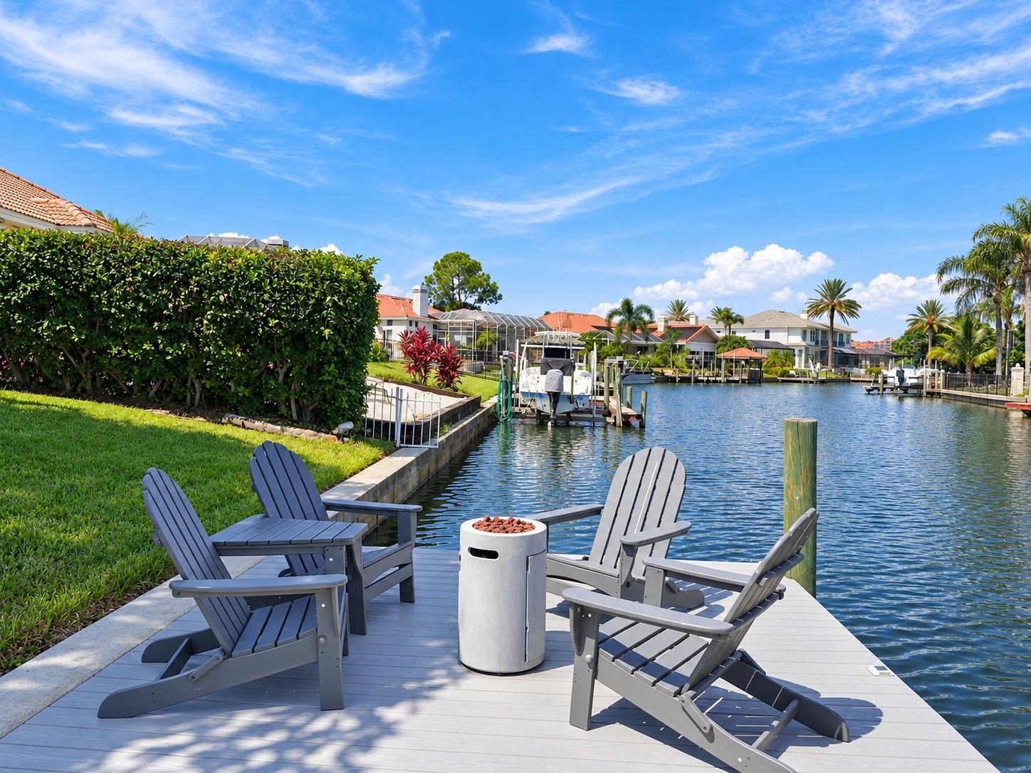 Welcome to waterfront living in the highly desirable, gated community of Bayside, where you can enjoy direct access to Tampa Bay and the Gulf of Mexico right from your backyard! This beautiful home offers a spacious, open floor plan with soaring ceilings, architectural details, and an abundance of natural light. Large windows showcase stunning water views from nearly every room, bringing the Florida lifestyle indoors. The stunning, completely renovated kitchen (2022) is the heart of the home, featuring gorgeous countertops with built-in outlets and wireless charging stations, a spacious breakfast bar, gas stove, built-in microwave, stainless steel appliances, and plenty of cabinetry for storage. Overlooking the inviting family room, complete with a cozy fireplace and built-in shelving, this space is perfect for everyday living and entertaining. Travertine flooring flows throughout the main living areas, adding warmth and timeless elegance. The thoughtfully designed split-bedroom floor plan offers an ideal blend of privacy and functionality. The spacious primary suite is a peaceful retreat, featuring beautiful water views and two generous walk-in closets. Both guest bathrooms were beautifully updated in 2025, including the bathroom adjoining the fourth bedroom, which also conveniently serves as a pool bath. Just off the kitchen, a dedicated laundry room offers added convenience with a utility sink and cabinets. Step outside and experience everything Florida waterfront living has to offer! The screened-in lanai features a sparkling saltwater pool, resurfaced in 2023, along with a new pool pump and heater for year-round enjoyment. Whether you're relaxing poolside, hosting friends for dinner under the covered lanai, or enjoying a quiet morning overlooking the water, this backyard is designed for making memories. Just beyond the pool, your private dock, beautifully updated in 2023 with durable composite decking, features a two-level design for easy access to paddleboarding, kayaking, and other water activities. Whether you're spending the afternoon fishing, gathering with neighbors for dockside cocktails, or hopping on your boat for a sunset cruise along Tampa Bay, endless waterfront adventures await right in your own backyard! Major improvements provide added peace of mind, including a tile roof (2018), completely renovated kitchen and new appliances (2022), interior paint (2022), exterior paint (2021), custom closets (2022), New front door (2021), outdoor lighting (2021), new garage door motor (2021), new pool pavers (2026), pool enclosure screens (2021), pool resurfacing and new tiles (2026), and dock improvements (2023). Garage equipped with an EV charging station. Bayside offers more than just beautiful waterfront homes. Residents enjoy a welcoming boating community with neighborhood events, including a festive lighted boat parade, playground, basketball court, tennis courts, pickleball courts and the opportunity to join the neighborhood yacht club. Conveniently located near Tampa International Airport, downtown Tampa, the Veterans Expressway, shopping, dining, and beautiful Gulf Coast beaches. The home is also just minutes from Berkeley Preparatory School. From morning coffee overlooking the water to sunset cruises from your own dock, this is the Florida lifestyle you've been dreaming of. Welcome home to Bayside!