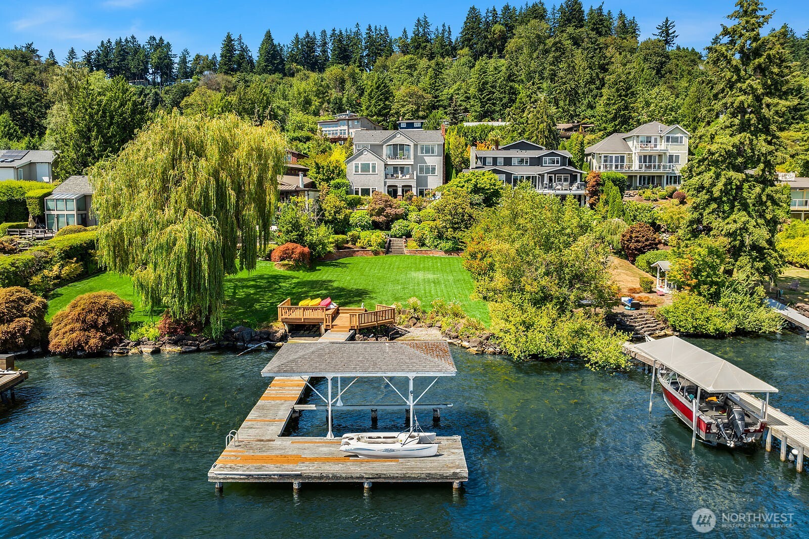 Experience superlative Northwest living in this sophisticated and joyous Mercer Island waterfront home. Delight in unobstructed stunning Mt. Rainier views from the private dock and airy and light five bedroom, five bath residence. This classic Cape Cod stunner offers soaring ceilings, hickory hardwood flooring throughout, a chef’s kitchen and three fireplaces. An unusually large, flat lawn and multiple entertaining decks invite seamless indoor-outdoor living for all to enjoy along with 69 feet of rare, low-bank shoreline, and a covered boat slip. Located in a sought-after enclave near the Mercer Island Beach Club, this home is both a private retreat and an entertainer’s dream.