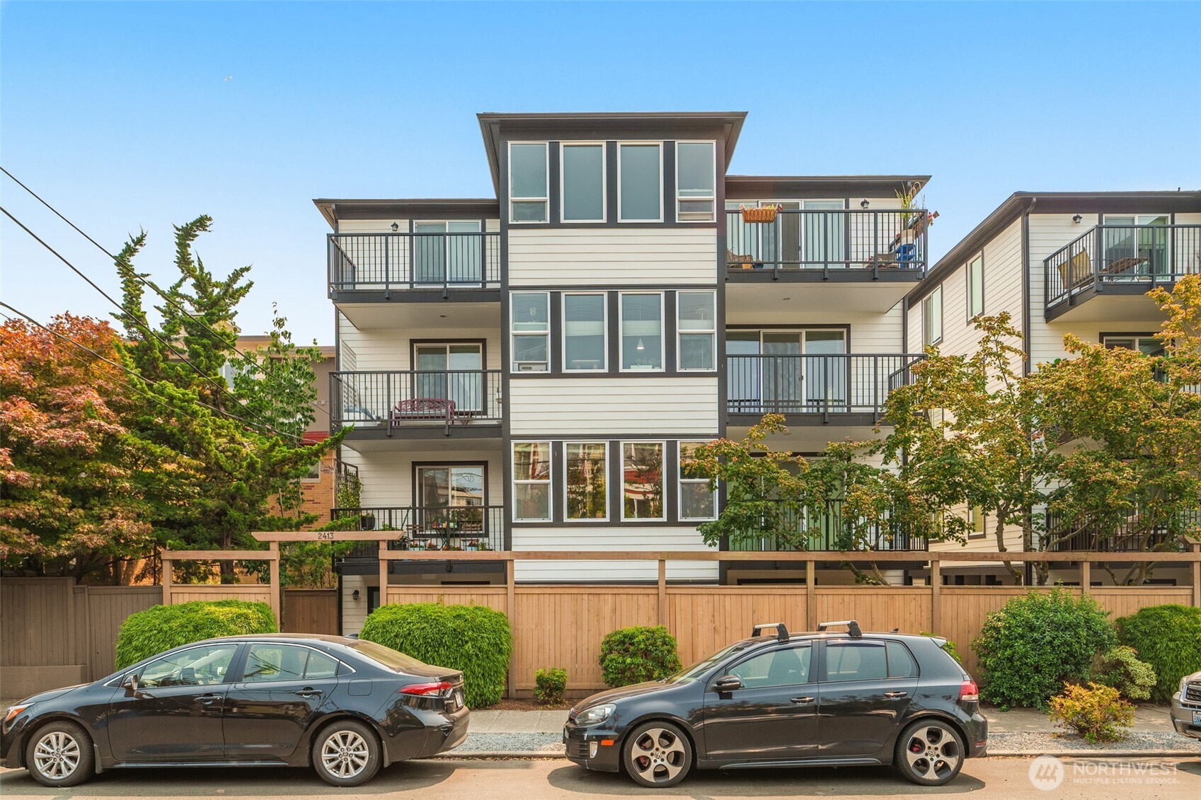 Bright, open, and move-in ready! Located in the heart of vibrant Ballard, this immaculate corner-unit condo offers a thoughtfully designed open-concept layout filled with natural light. The generous dining area flows seamlessly into the spacious living room and well-appointed kitchen featuring stainless steel appliances, slab countertops, and ample cabinetry. Step onto your private covered balcony—perfect for morning coffee or relaxing after a busy day.    The main living areas and bedroom feature beautiful hardwood flooring, creating a warm and timeless feel. The spacious full bath includes a beautifully tiled shower surround. Additional highlights include an in-unit washer and dryer, a covered parking spot, and HOA improvements completed in 2025, including new siding, roofs, windows, deck railings, and painting providing added value and peace of mind.    Enjoy the best of Ballard living with trendy cafés, restaurants, craft breweries, boutiques, parks, and the Ballard Locks nearby. Convenient access to Downtown Seattle, Fremont, and Golden Gardens makes this an exceptional place to call home or invest.    No rental cap!