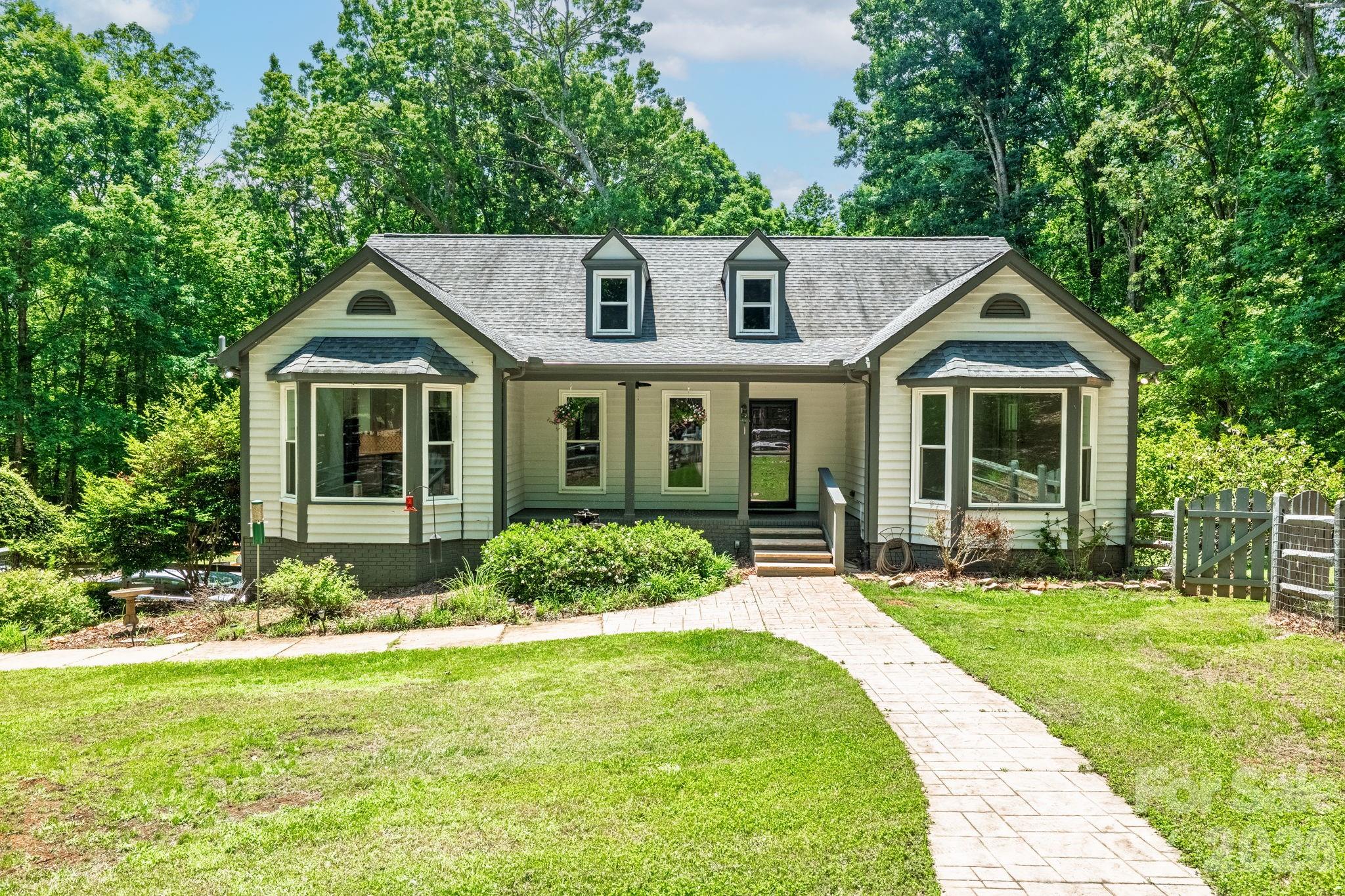 Properties like this rarely become available, offering a unique chance to enjoy over 5 acres of privacy and space in an exceptionally convenient location only 20 minutes to Uptown, 15 minutes to Plaza Midwood, and less than 5 minutes to I-485. This custom-built home features 3 bedrooms, 2.5 bathrooms, and an extensive list of high-end updates throughout.A circular driveway and gated front yard welcome you to the charming rocking-chair front porch. Inside, natural light pours through the home, enhanced by a stunning glass-paneled wall between the dining room and great room. The beautifully renovated kitchen is designed for both everyday living and entertaining, featuring quartz countertops, a large center island, designer tile backsplash, stainless steel appliances, and a bright breakfast area.The great room boasts a vaulted ceiling, a gas fireplace, and French doors that open to a spacious porch overlooking the serene backyard and surrounding acreage. The main-level primary suite serves as a private retreat, complete with a luxurious spa-inspired bath featuring a freestanding copper tub, separate shower, premium toilet/bidet combination, and walk-in closet. Just beyond, a sunroom or home office offers peaceful backyard views and direct access from the primary bath.The main level also includes a convenient laundry room and powder room. Downstairs, the bright daylight walk-out basement provides exceptional additional living space with a second great room featuring an electric fireplace, two spacious bedrooms, and a Jack-and-Jill bathroom. Large windows bring in abundant natural light, creating a warm and welcoming atmosphere throughout the lower level.Outdoor living is equally impressive with a newly installed sauna, backyard irrigation system, fire pit with stamped concrete patio, and expansive grounds that offer endless opportunities for recreation, relaxation, or future enhancements. Recent improvements include new windows, interior and exterior doors, a tankless water heater, water softener system, and a whole-house generator. The oversized garage features an epoxy-coated floor, workshop space, and ample storage.With its combination of acreage, privacy, luxury upgrades, and an unbeatable location inside I-485, this is a truly rare offering. There are simply too many special features to list. Schedule your private showing today and experience everything this remarkable property has to offer.