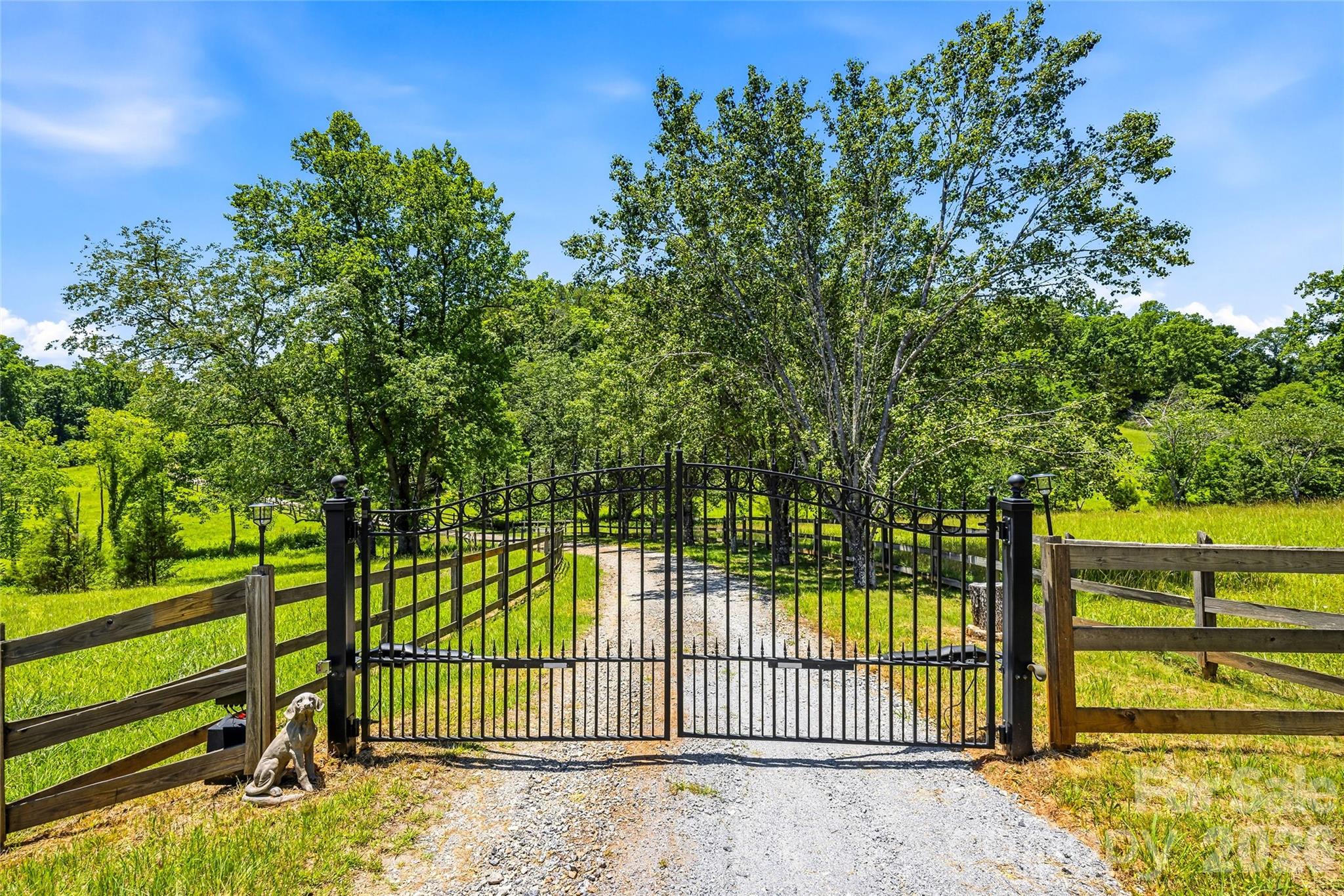 Spectacular 40-acre equestrian estate in the foothills of the Blue Ridge Mountains, just minutes from the Tryon International Equestrian Center. Privacy, craftsmanship, history and location converge in this extraordinary Western North Carolina retreat. Completely hidden from the road and neighboring properties, the main residence rests atop the estate, offering a rare combination of seclusion and accessibility. The upper level features two en-suite bedrooms, including a luxurious primary suite with a spacious spa-inspired bath featuring a jetted soaking tub. Designed for everyday living and entertaining, the main level offers multiple gathering spaces, including two sitting rooms, a fireplace, multiple dining areas and two powder rooms. The updated kitchen features high-end appliances, abundant workspace and a generous pantry. A large rear deck spans the width of the home, creating the ideal setting for outdoor dining and enjoying the surrounding landscape. The walkout lower level provides exceptional flexibility with a recreation room featuring a fireplace, exercise room, workshop and additional finished spaces ideal for guests, hobbies or extended entertaining. A private drive leads to the separate one-bedroom residence featuring a full kitchen, full bath, laundry facilities and wrap-around deck. The lower level includes a three-car garage with individual bays, a half bath, and extra hobby space. Fenced outdoor areas provide a welcoming environment for pets. A fire pit gathering area connects the secondary residence to the impressive 40-by-50-foot four-stall barn, which features large sliding doors, side garage-style doors and direct access to one of four fenced pastures totaling approximately 10 acres. The large hayloft has been transformed into an exceptional entertaining space with a 24-foot table comfortably accommodating large gatherings. Additional amenities include dedicated RV and horse trailer parking with two 220-volt hookups and easy turnaround. The property reflects the rich heritage of Western North Carolina, a region known for its historic gold mining and mountain traditions. The creek bordering the southern boundary highlights the area’s prospecting history. Beyond the estate, enjoy easy access to world-class equestrian events, championship golf, river recreation, wineries, fox hunting, Lake Lure, hiking trails and numerous historic sites throughout the mountains. Furniture, equipment and additional furnishings are available separately, providing a rare opportunity to acquire a turnkey mountain equestrian lifestyle property.