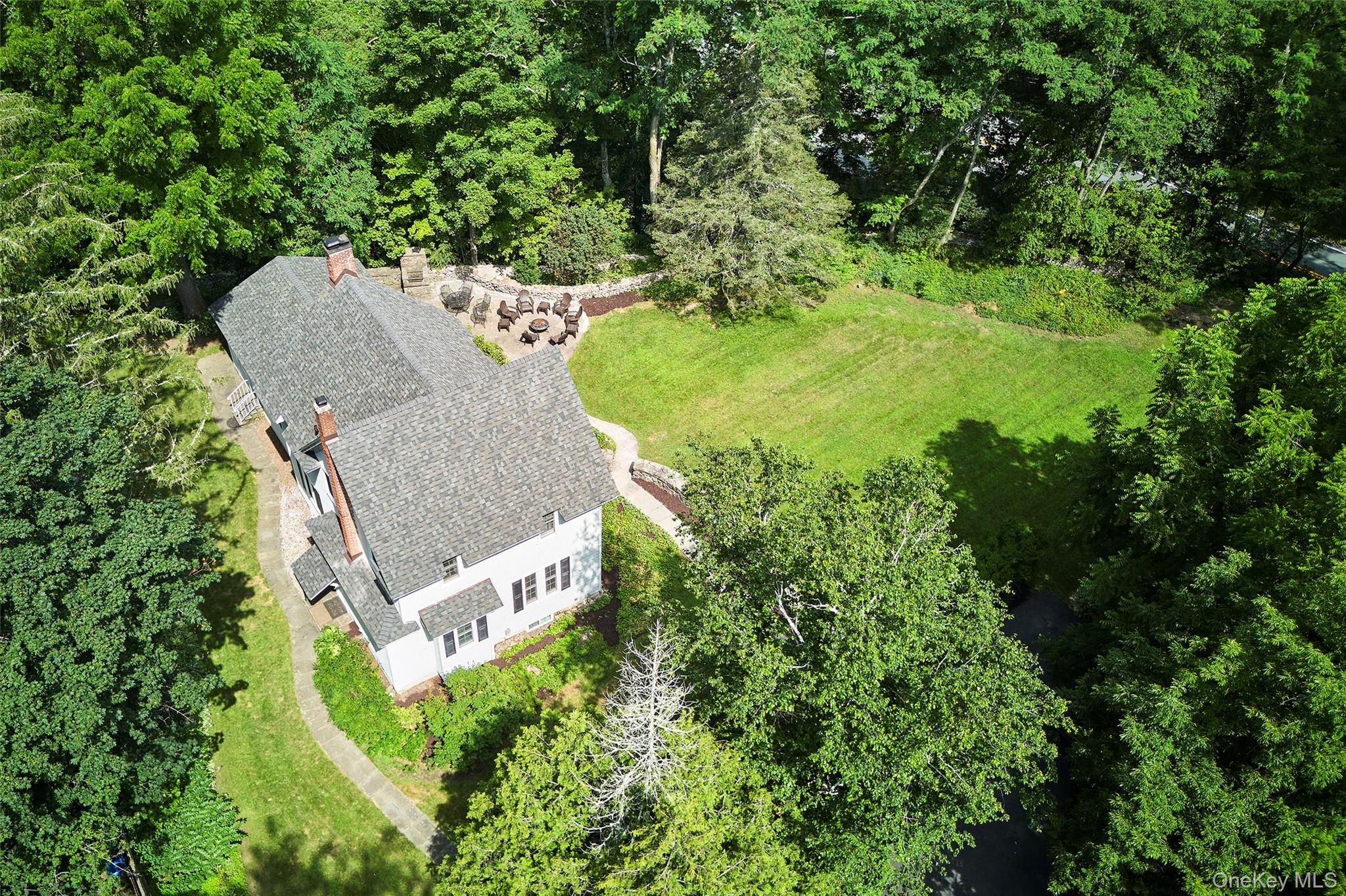 Aerial view of property and surrounding area with a heavily wooded area