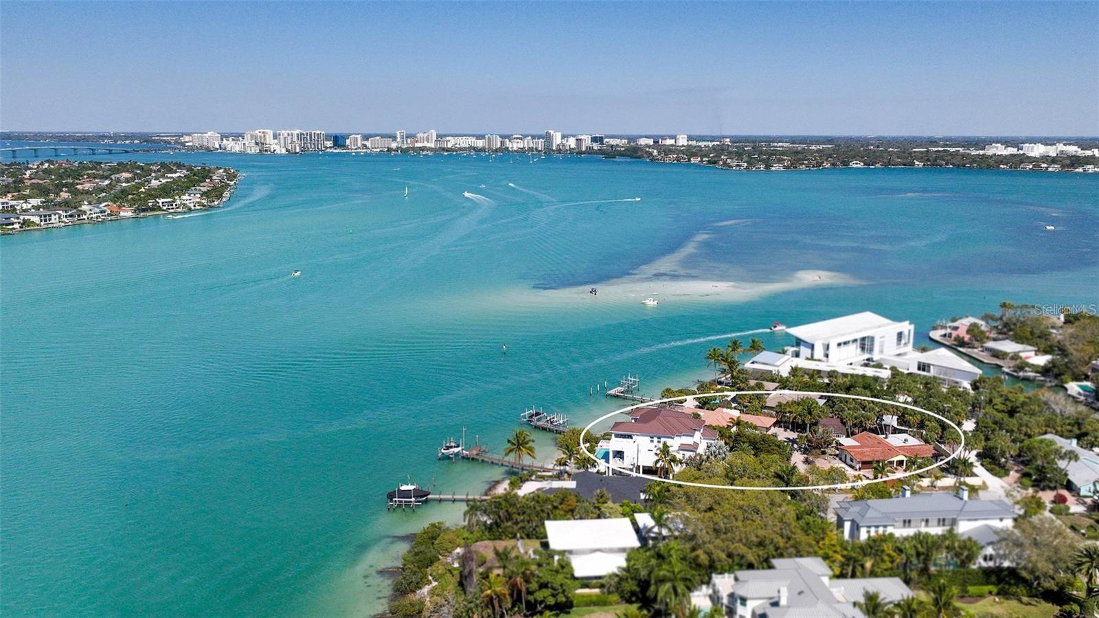 Rarely available! A rare jewel is now available: It's all about the view and the location. This Beachfront & Bayfront Estate Size Home Site for your dream residence or family compound is now available.......This prime homesite (10 minutes to downtown) offers unparalleled vistas of the glistening waters, downtown Sarasota, and Bird Key and Lido Key from its expansive 120-foot frontage of private beach, bay, and pass frontage. This exclusive property is among the few that capture downtown views on the NORTHERN TIP of SIESTA KEY and presents an extraordinary opportunity to own a piece of Siesta Key's most reputable bayfront locations. This unique offering combines two properties into one expansive estate-family compound featuring breathtaking waterfront views, direct beach access, a deepwater boat dock on Big Pass, and 2 protected boat slips on Bayou Louise. It provides a canvas for a dream home nestled in a secluded enclave of private luxury homes. With its significant land size of almost ¾ acres and prime location, it represents a rare blend of sophistication and coastal living in paradise. This is an unparalleled opportunity to create a bespoke estate in a neighborhood known for its exclusivity and high real estate values.An exceptional opportunity — this property may be purchased together with the neighboring lot/home MLS# A4668034 to create a spectacular compound in one of Siesta Key’s most coveted locations.