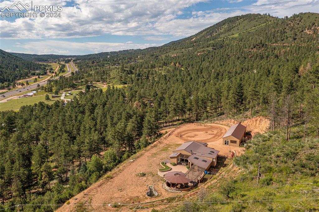 Over 11 acres of beautiful mountain property with Pikes peak view! Home is a beautiful rancher on top of the world with 360 degree mountain views, quality construction, open floor plan, tall ceilings, a natural light paradise, wall with extra large windows, new high end kitchen, on demand hot water, privacy and many extras. This home is great for entertaining and you can host many people on the patio, large flat yard around the home. 4th bedroom non conforming could be used as bedroom or game room or bonus room! 285' of highway 24 frontage. Some flexibility with this RT zoning.
Kiva(extra large fire pit)- wonderful place to enjoy family and friends. 2 water heaters two furnace, well and septic.

Garage- very large for storage and parking and the work out room is a part of this building, 
Studio/Shop- very large 37x20 with wall heat, plenty of light and electrical, close to the highway not as close to the home
Well & septic. 

Possibilities: current zoning R-T allows for many options as is, investors and developers consider possibilities.