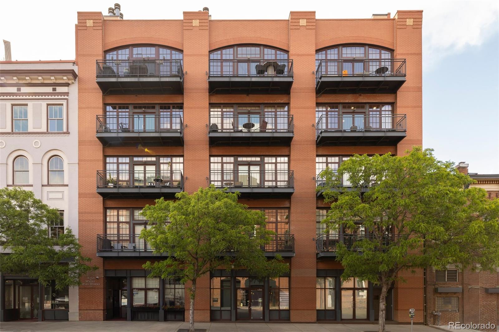 Wake up to the rhythm of the city and just outside you're exactly where you want to be. Set in the heart of LoDo, just moments from the Platte River, this two-story loft in the Wire Works building puts you at the center of everything Denver is becoming. With major entertainment districts and riverfront development on the horizon, this is more than a residence, it’s a front-row seat to what’s next and we should be excited for what is to come in Denver! Inside, the space tells its own story. Exposed brick, soaring ceilings, and the incredible natural light creates a warm, urban backdrop, while a complete renovation has reimagined all of the details with intention. The layout flows effortlessly, blending open living with quiet, private retreats. The kitchen anchors the space with a large island, generous storage, a pantry, and also has the city views that make even everyday moments feel connected to the energy outside. Two ensuite bedrooms offer comfort and flexibility, while a dedicated wellness space invites you to slow down, whether that means morning yoga, a workout, or simply a moment to reset, complete with a built-in filtered water station. Upstairs, the primary suite feels like a true escape, with a steam shower, heated floors, and a generous walk-in closet. Two balconies extend your living space outdoors, offering city and mountain views that remind you exactly where you are. Little details not to be missed, automated window coverings, it's fully furnished and move-in ready, there are pocket doors, the ability to decorate modern or traditional, wine storage, and more! It's the perfect city space and can be yours. This is loft living at its best. Designed for how you live now, and perfectly positioned for what’s ahead!